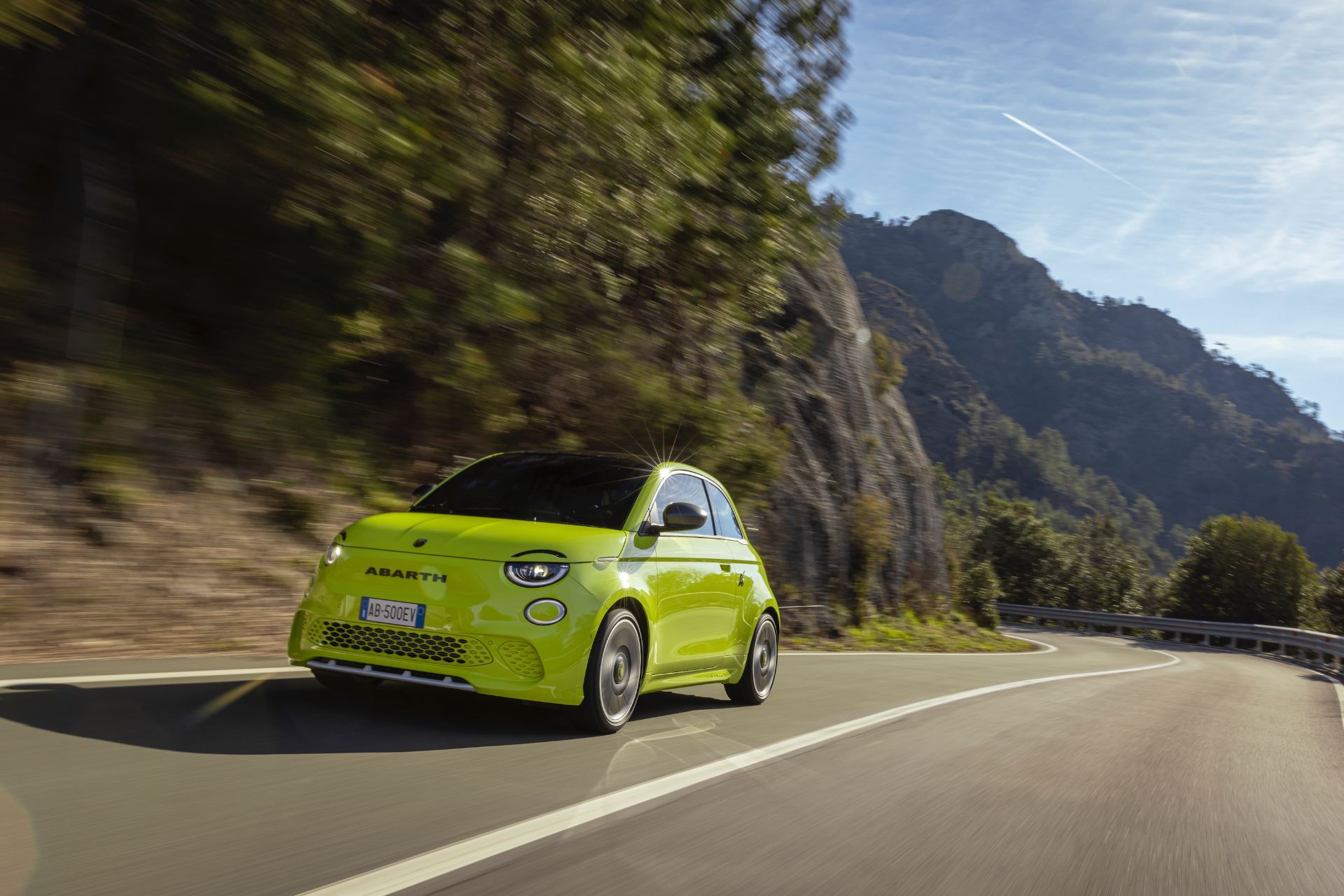 2024 abarth 500e driving front three quarter mountain road green