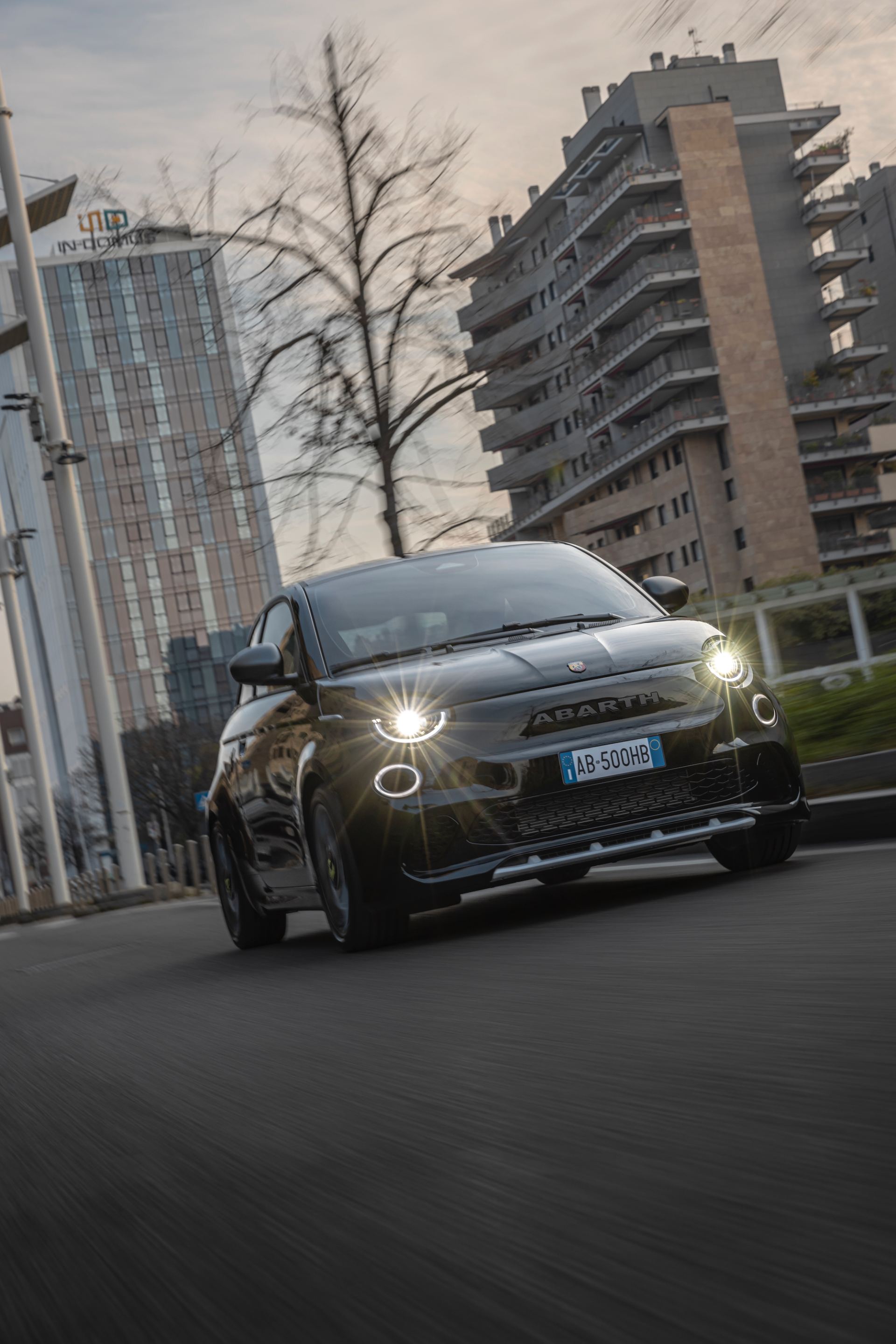 2024 abarth 500e driving front apartment towers black