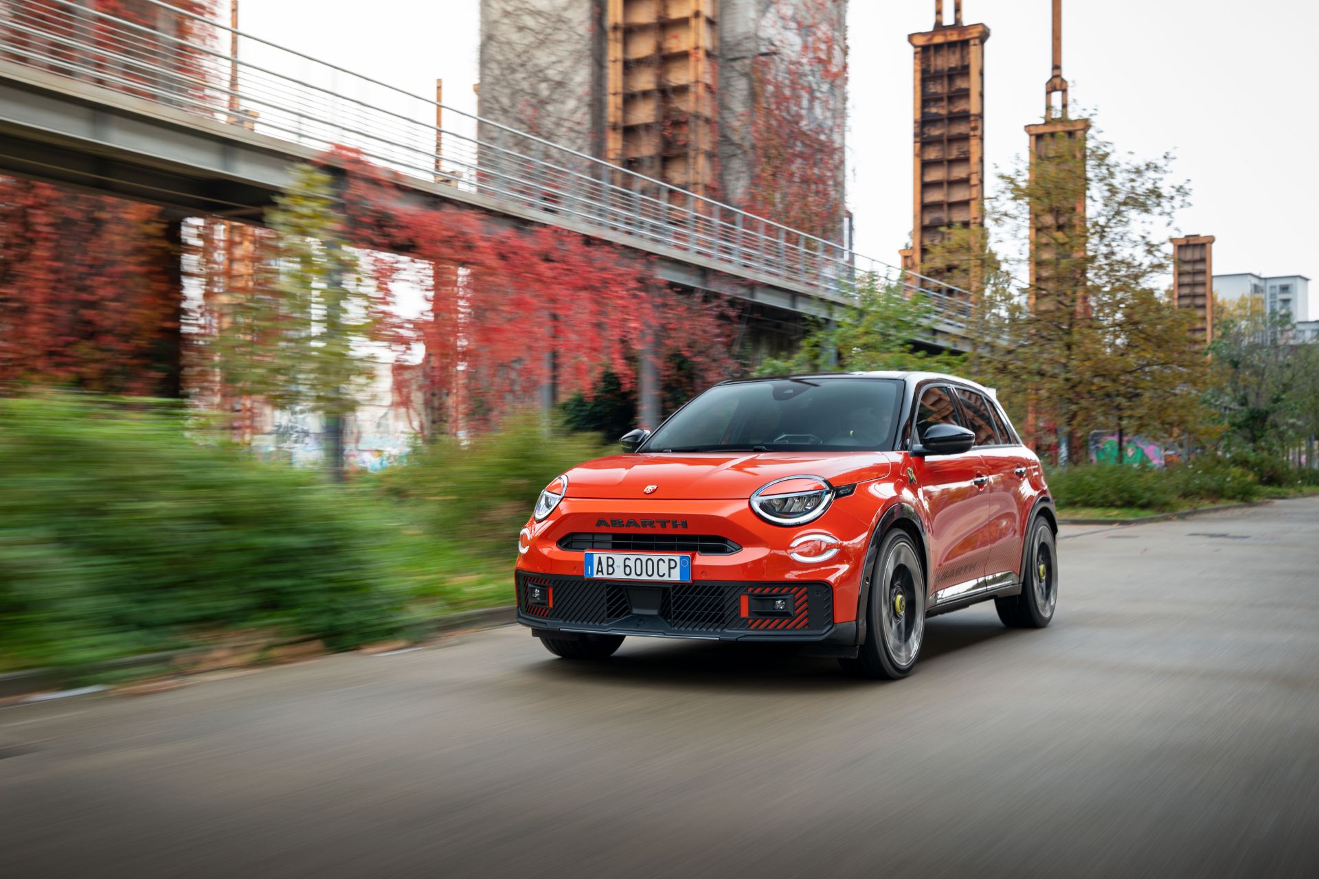 2025 abarth 600e driving front three quarter orange