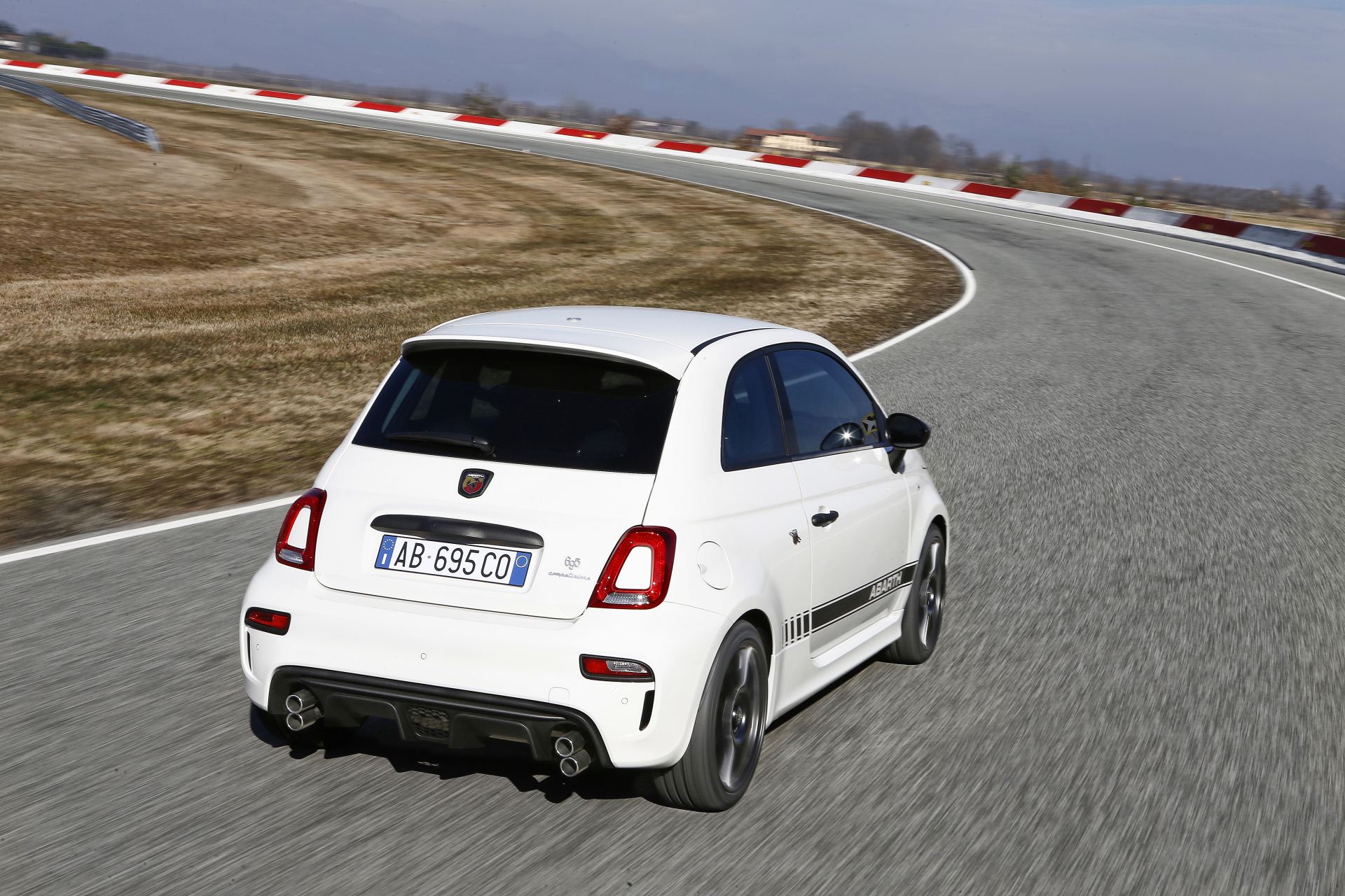 2024 abarth 695 driving rear three quarter track white