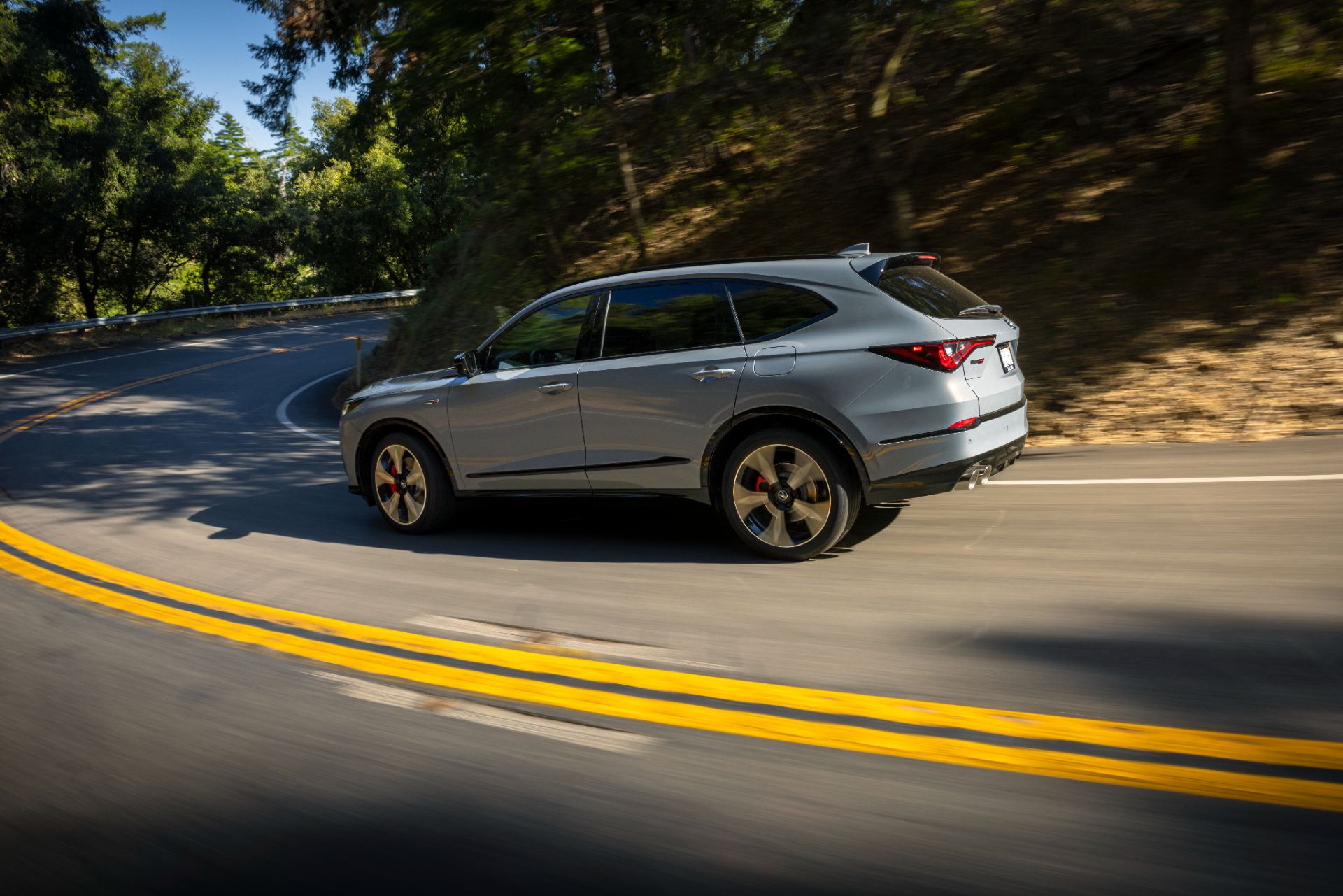 acura mdx type s driving rear three quarter winding road grey