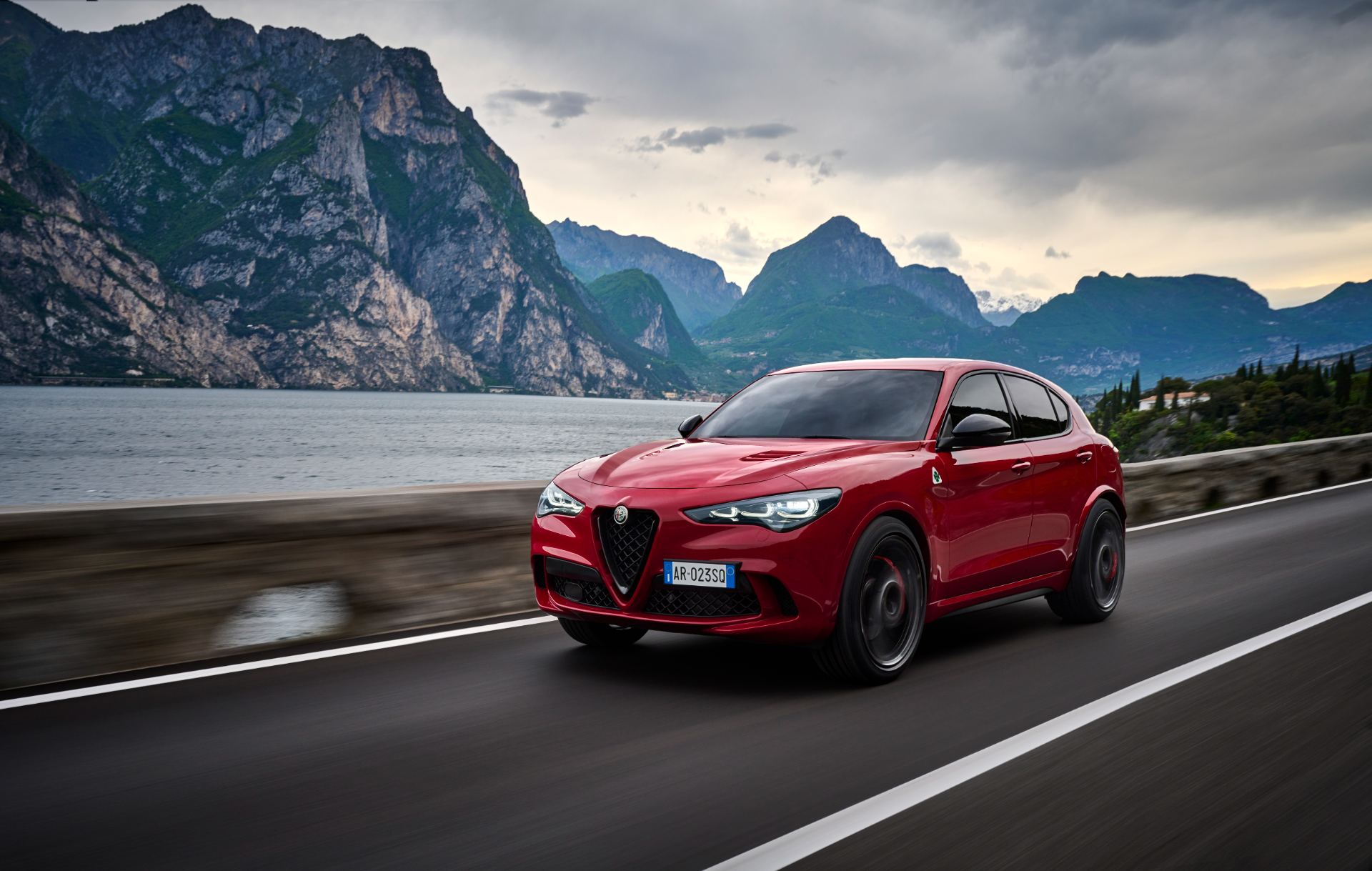 2026 alfa romeo stelvio quadrifoglio driving front three quarter lake road red