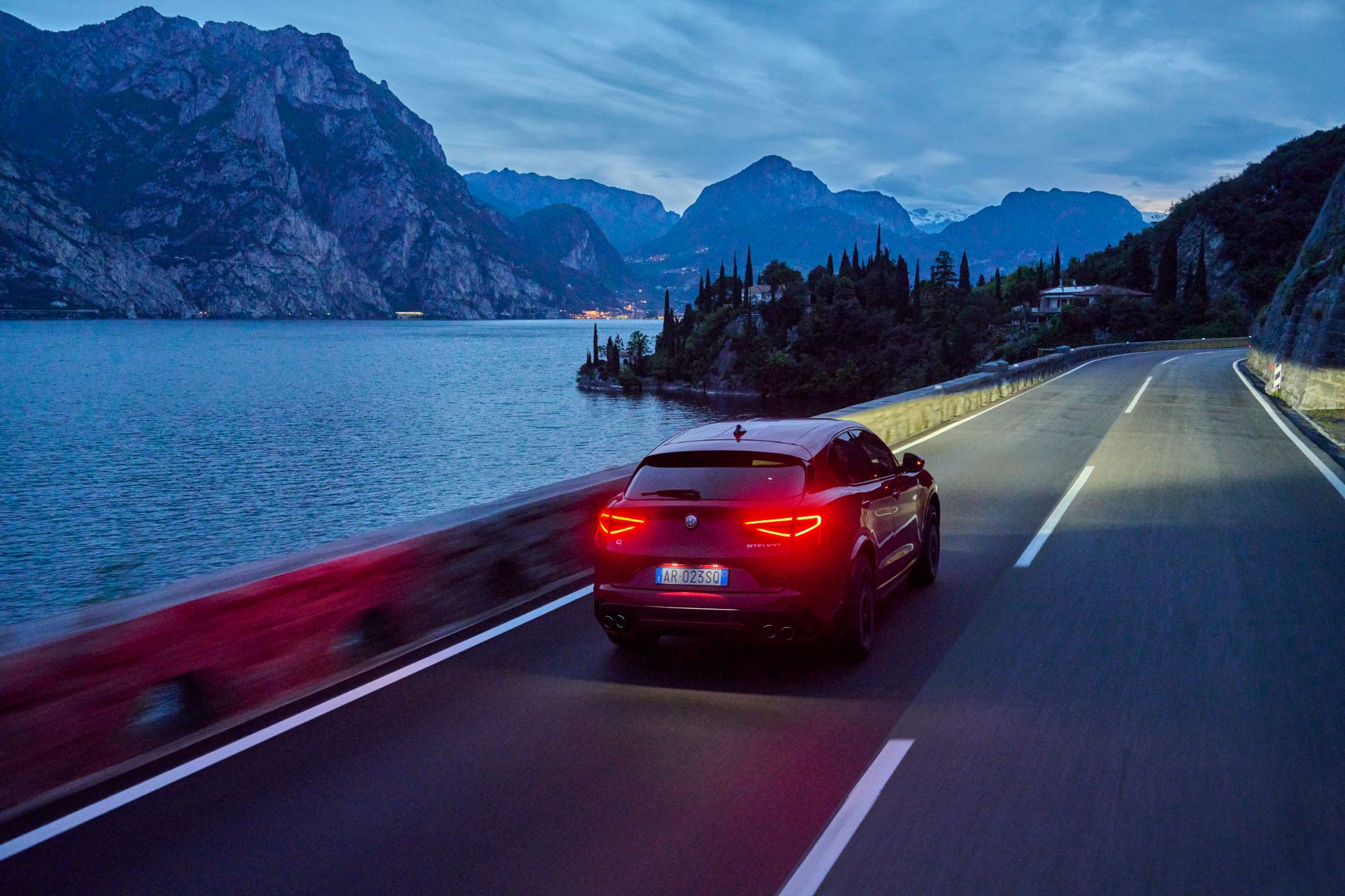 2026 alfa romeo stelvio quadrifoglio driving rear lake road dusk red