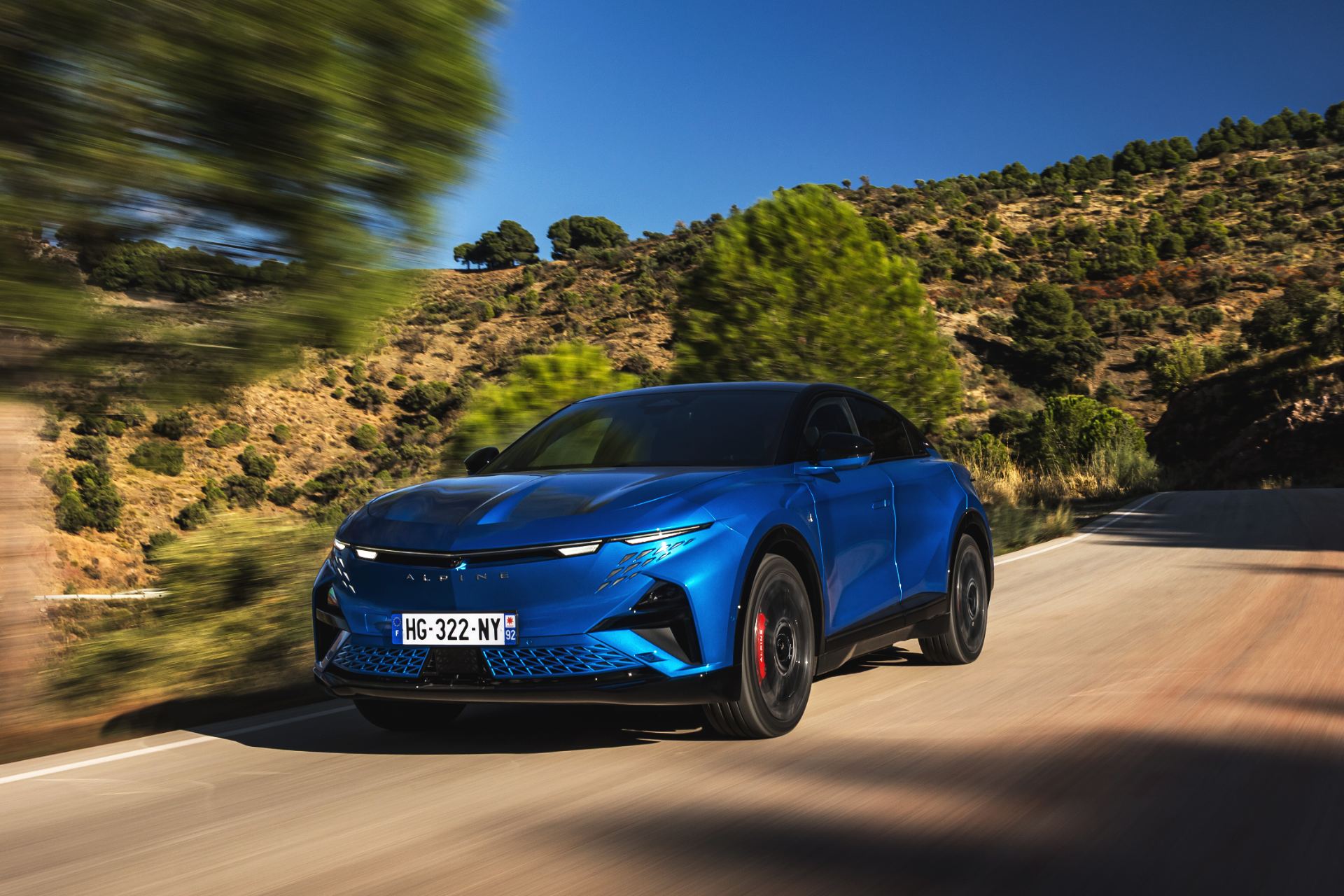 2026 alpine a390 gt driving front hillside road alpine vision blue