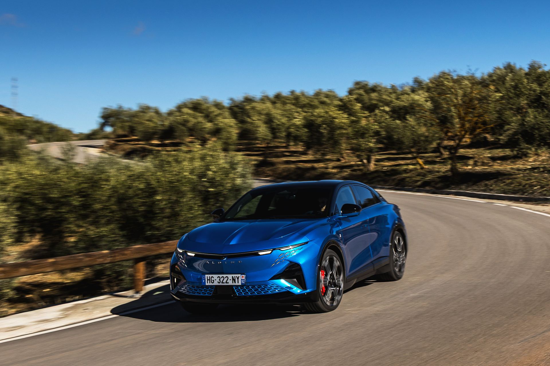 2026 alpine a390 gt driving front three quarter winding road alpine vision blue