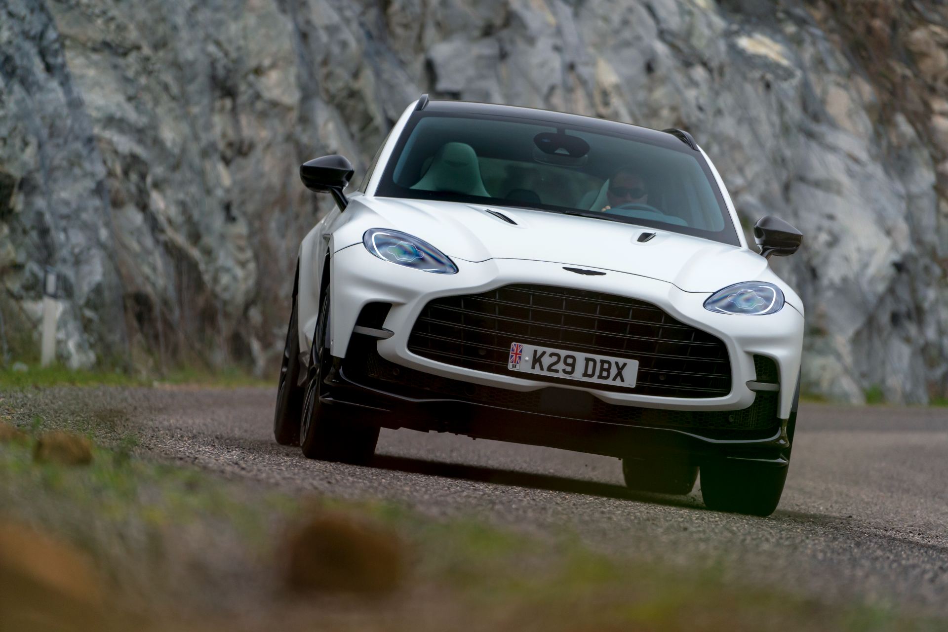 2026 aston martin dbx707 driving front rock wall white