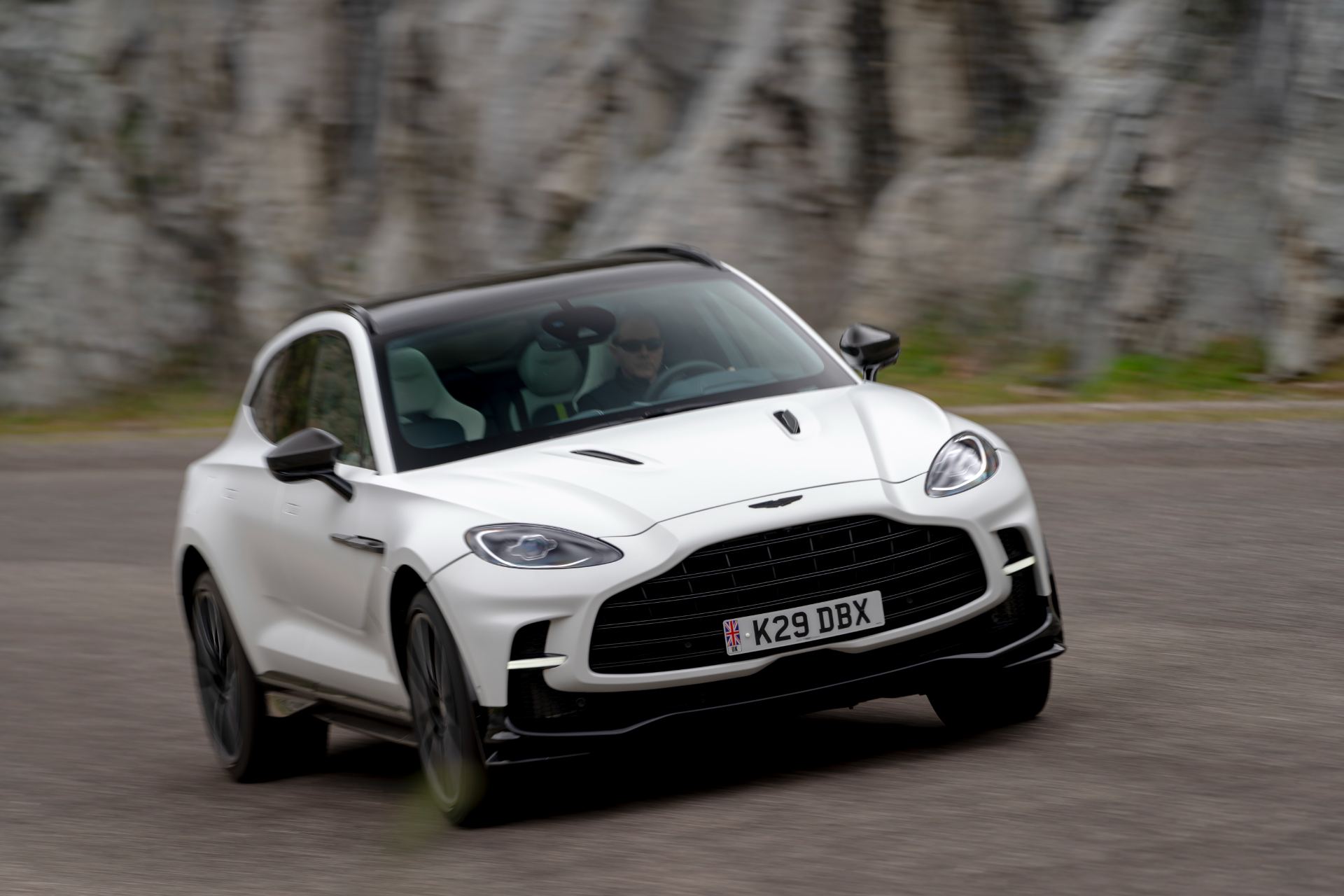 2026 aston martin dbx707 driving front three quarter close white