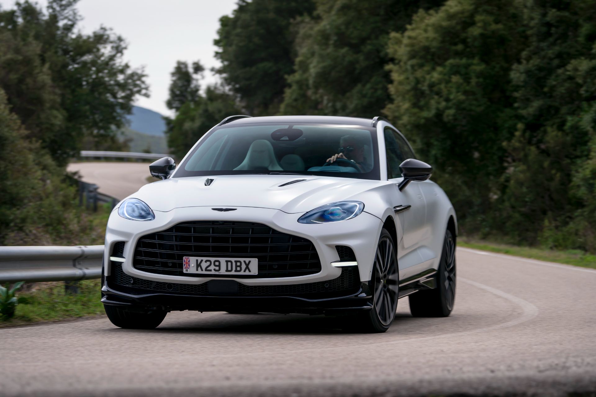 2026 aston martin dbx707 driving front three quarter hairpin white