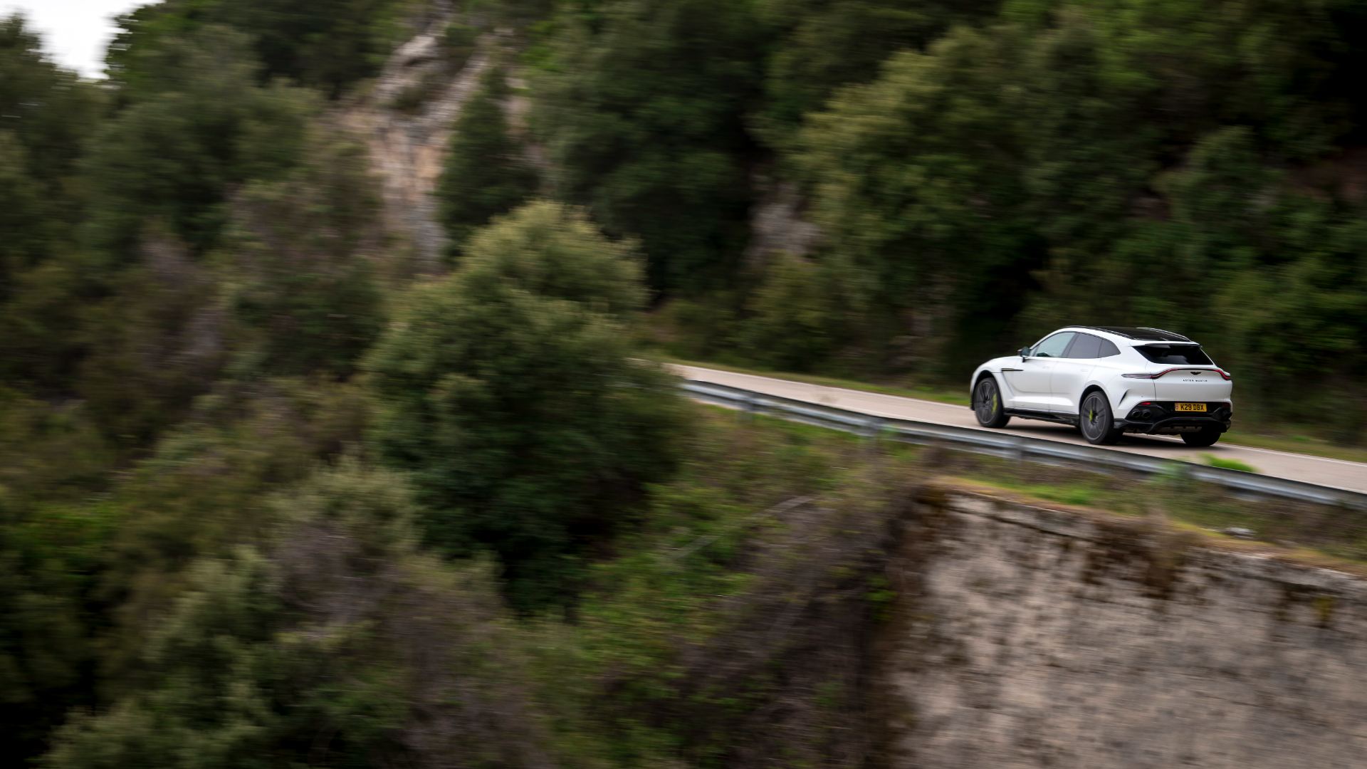 2026 aston martin dbx707 driving distant coastal road white