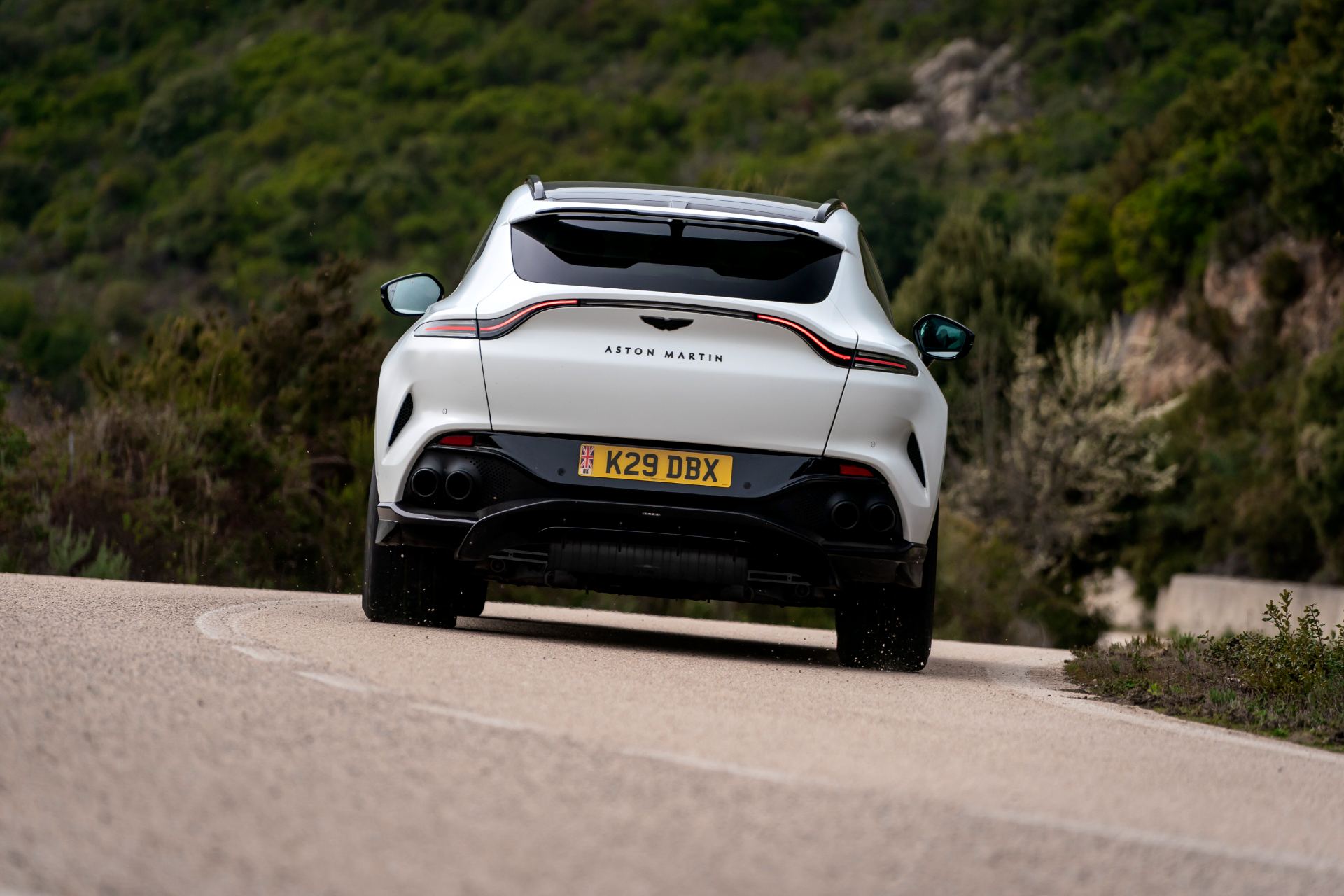 2026 aston martin dbx707 driving rear hillside white