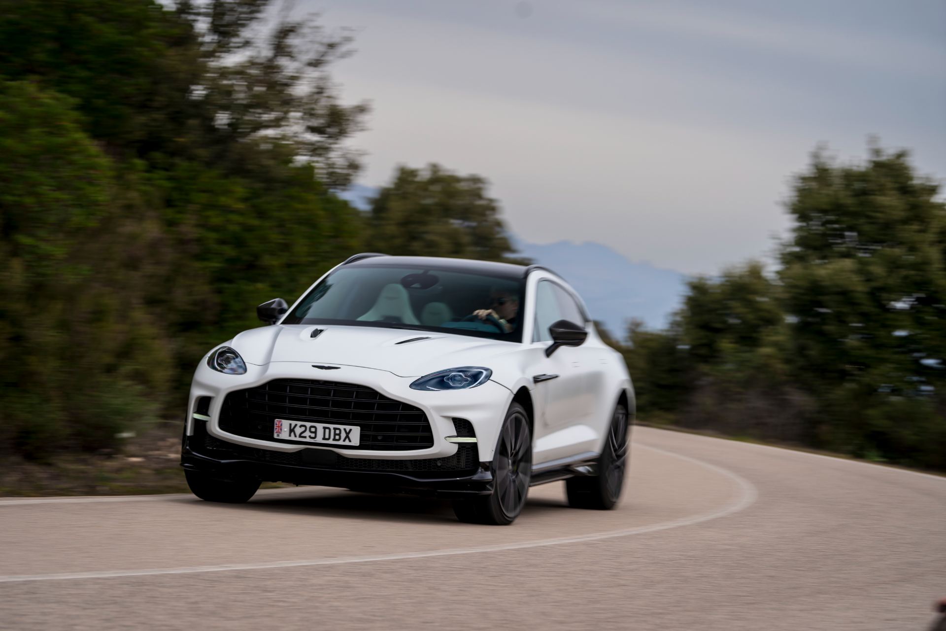 2026 aston martin dbx707 driving front three quarter bend white