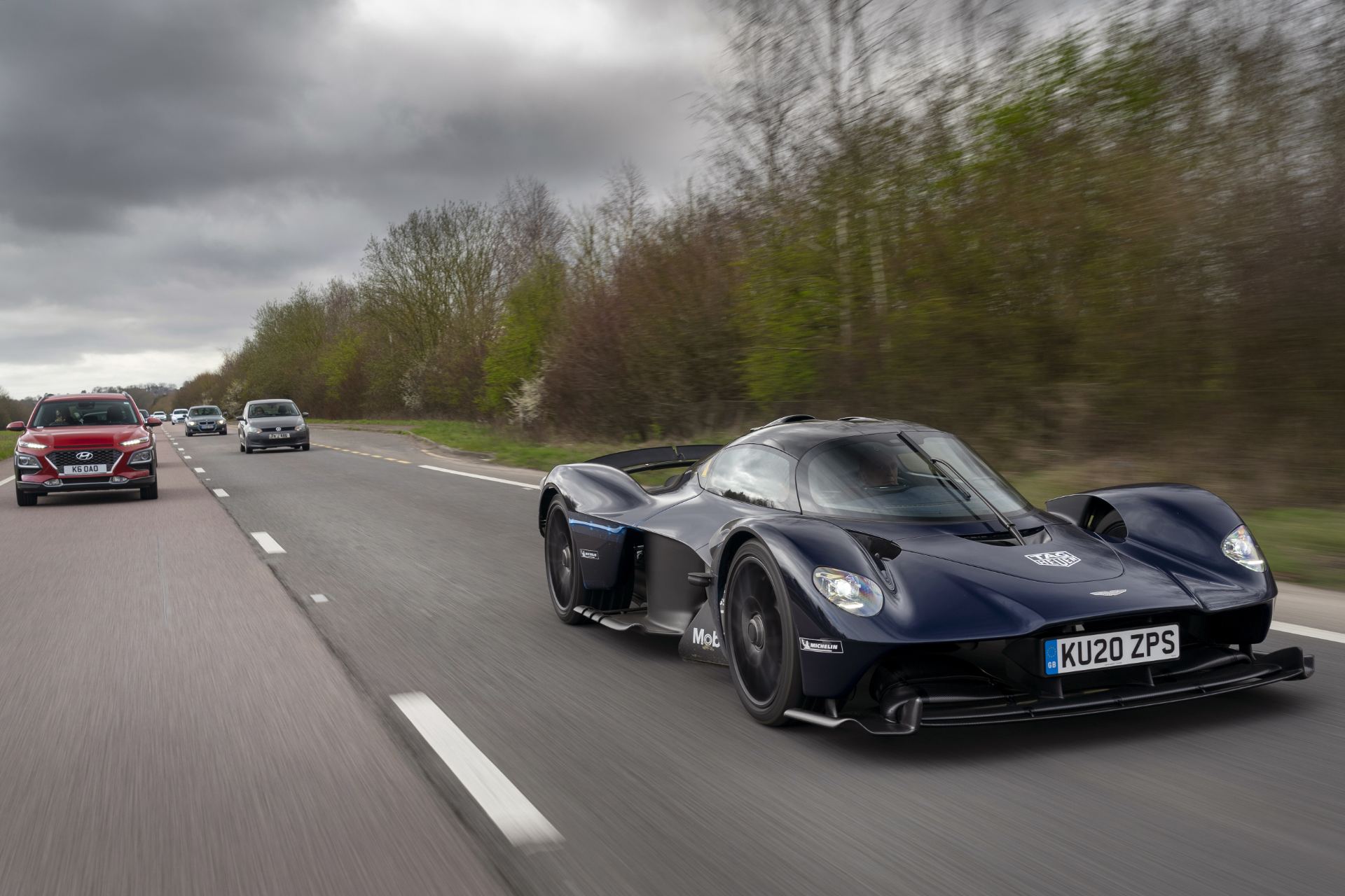 2026 aston martin valkyrie driving front three quarter country road dark blue