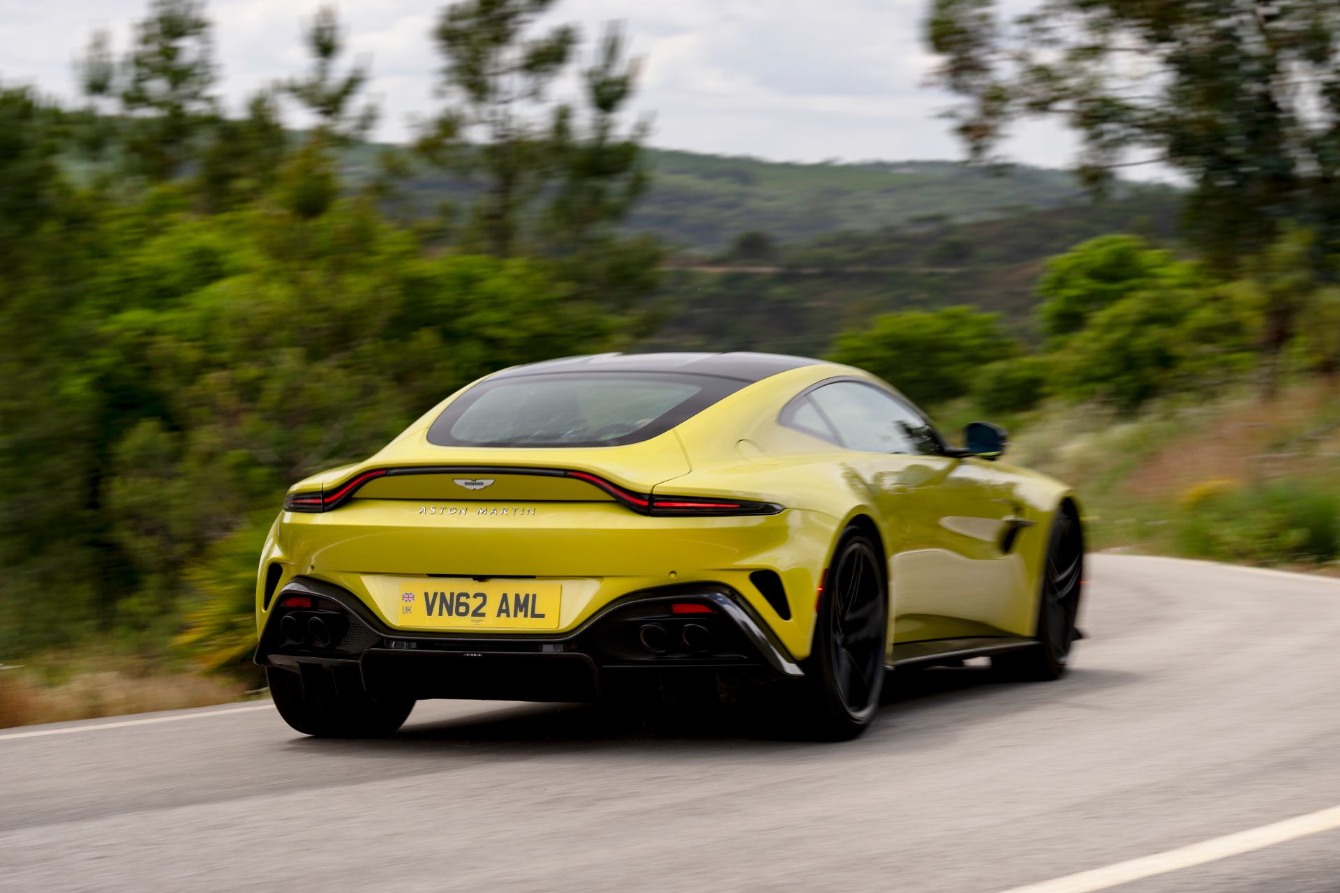 2026 aston martin vantage driving rear three quarter yellow