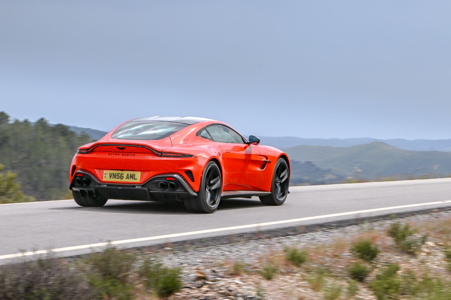 2026 aston martin vantage driving rear three quarter cosmic orange