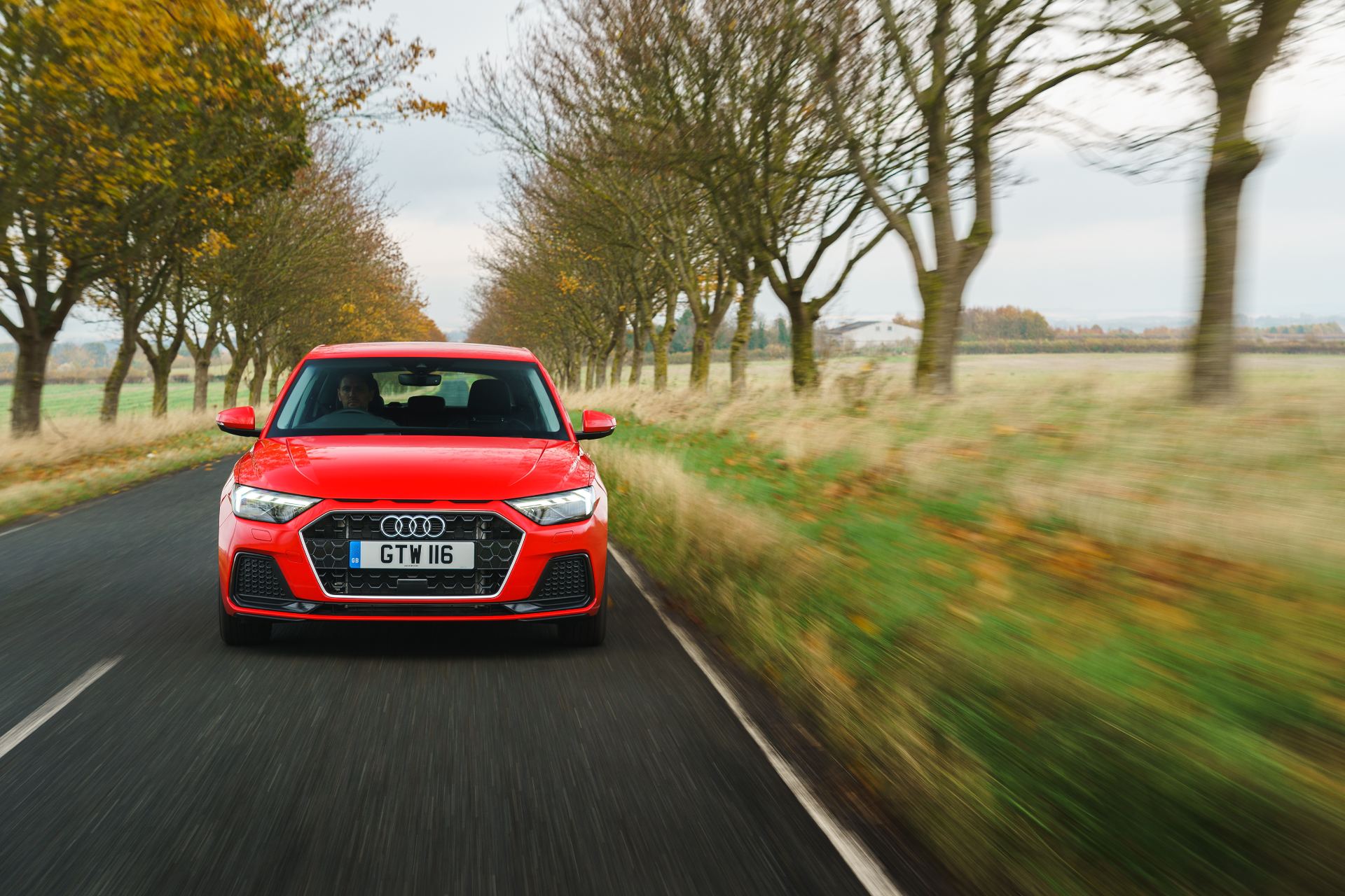 2026 audi a1 sportback sport driving front tree lined road red