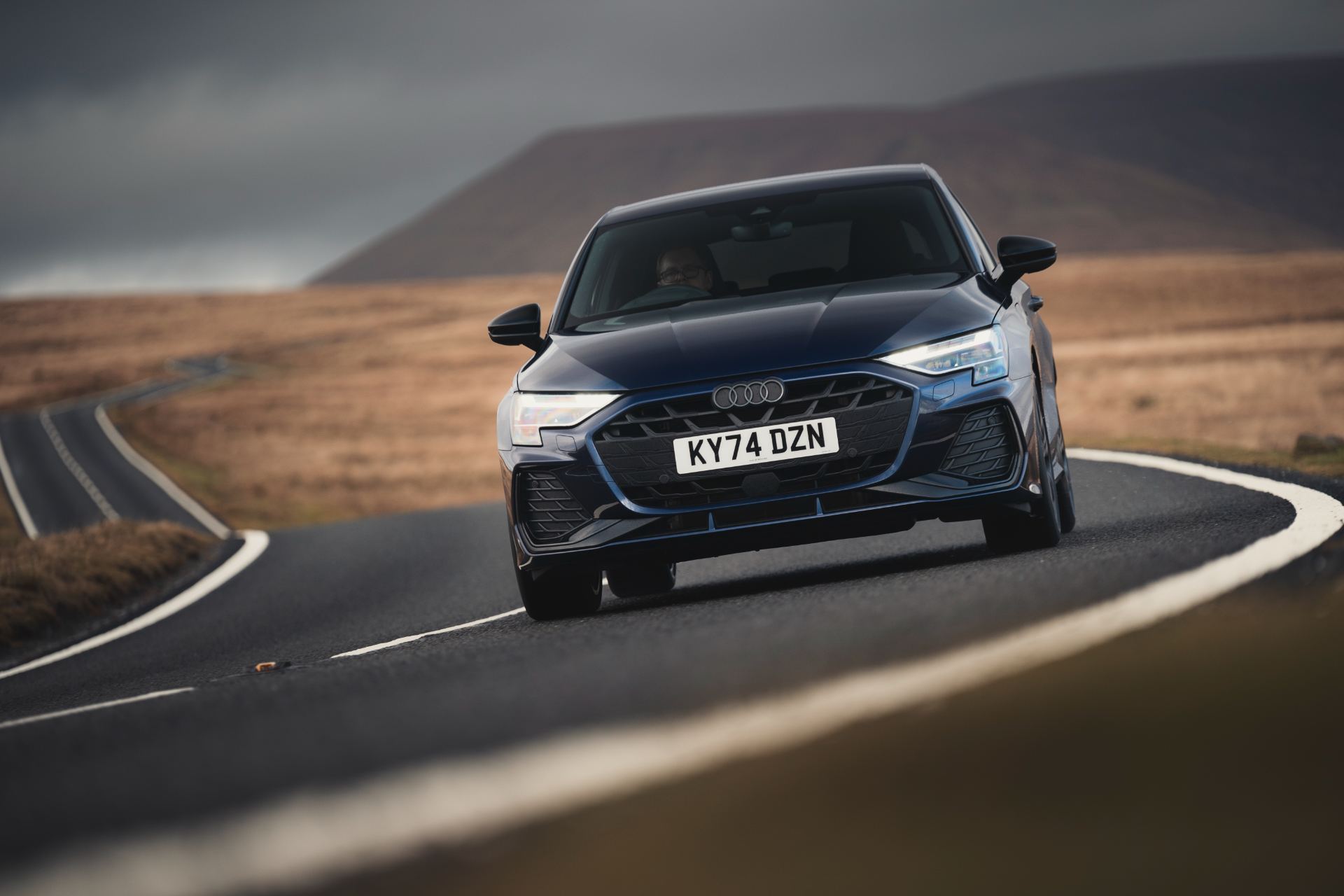 2025 audi a3 sportback tfsi e driving front winding road blue