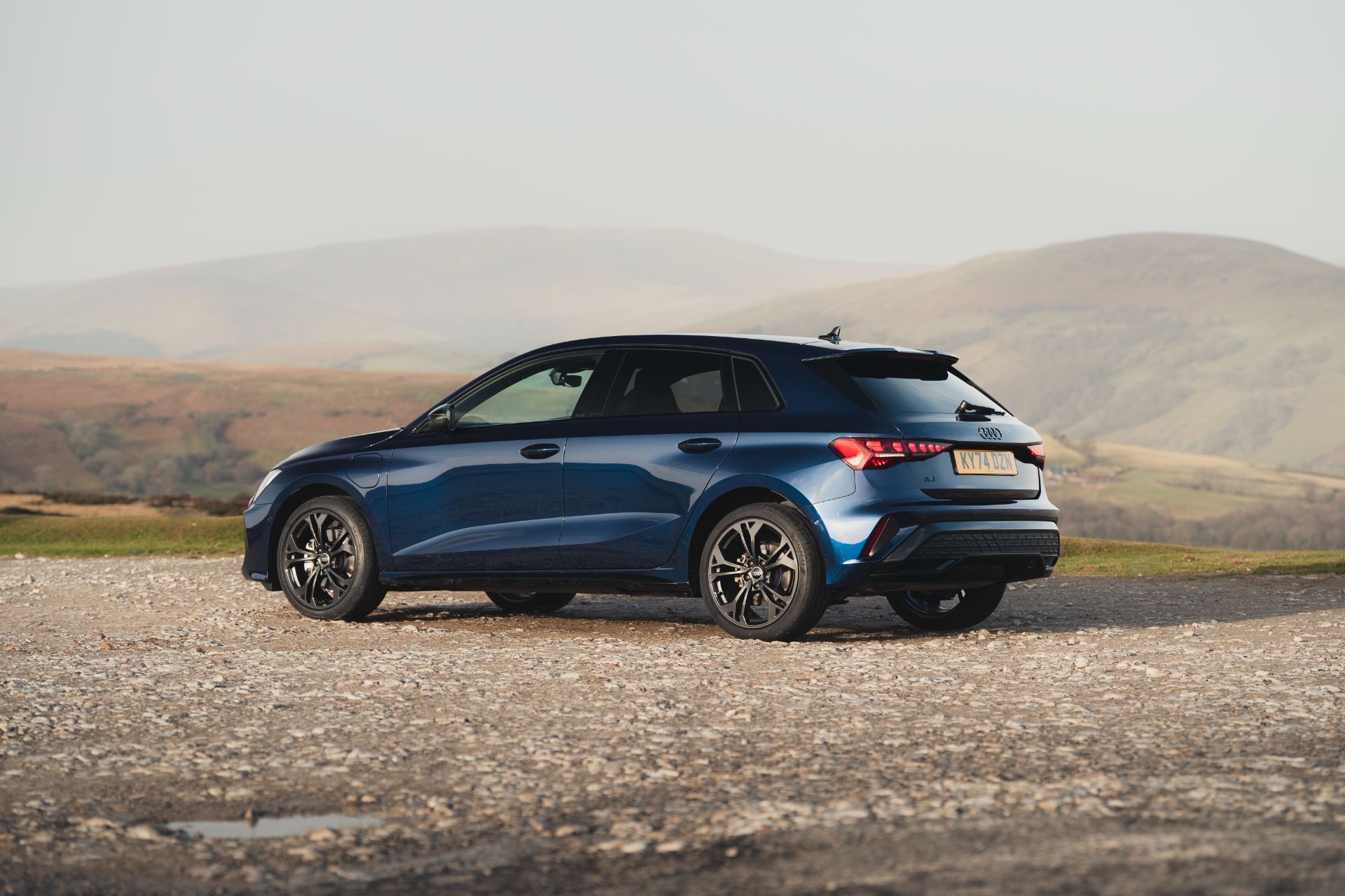 2025 audi a3 sportback tfsi e rear three quarter hills blue
