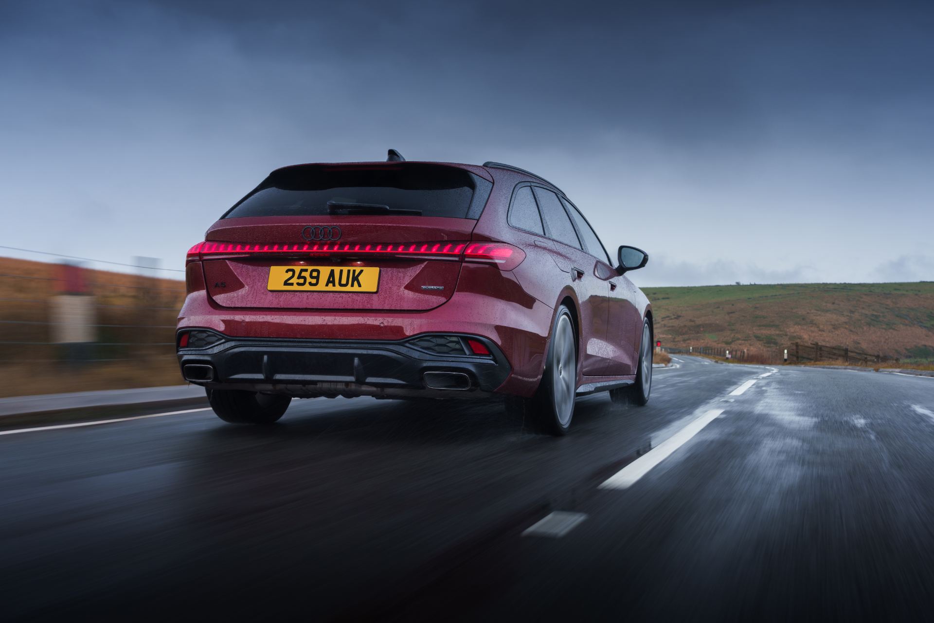 audi a5 avant driving rear three quarter wet road red