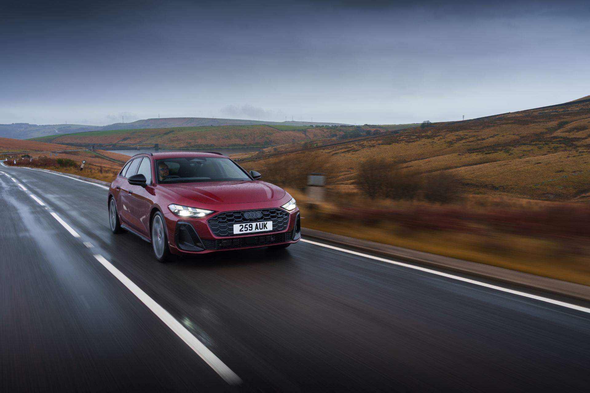 audi a5 avant driving front three quarter distant red