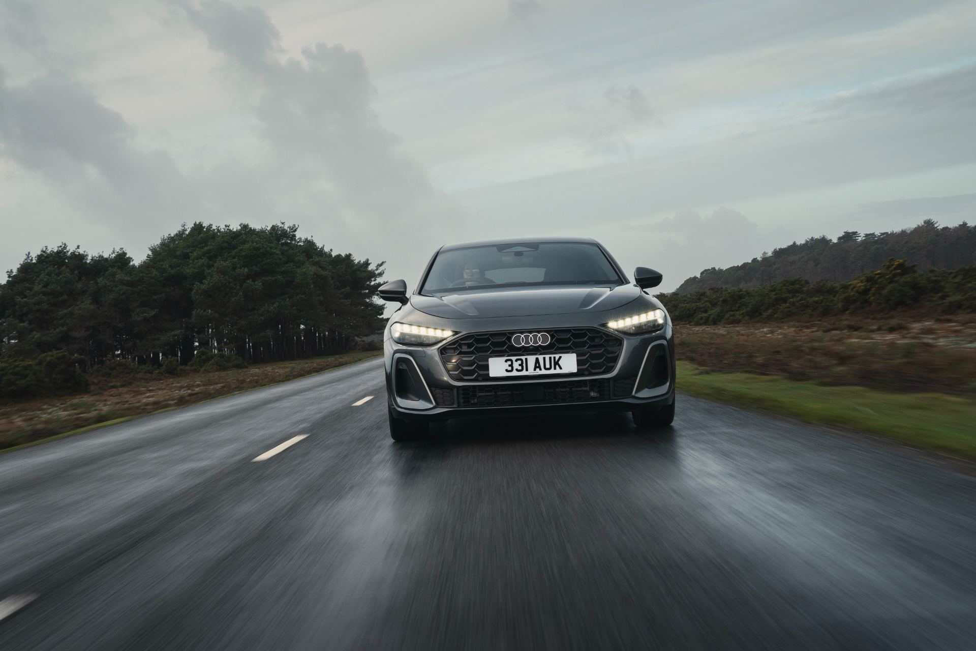 2026 audi a5 saloon e hybrid driving front wet road grey