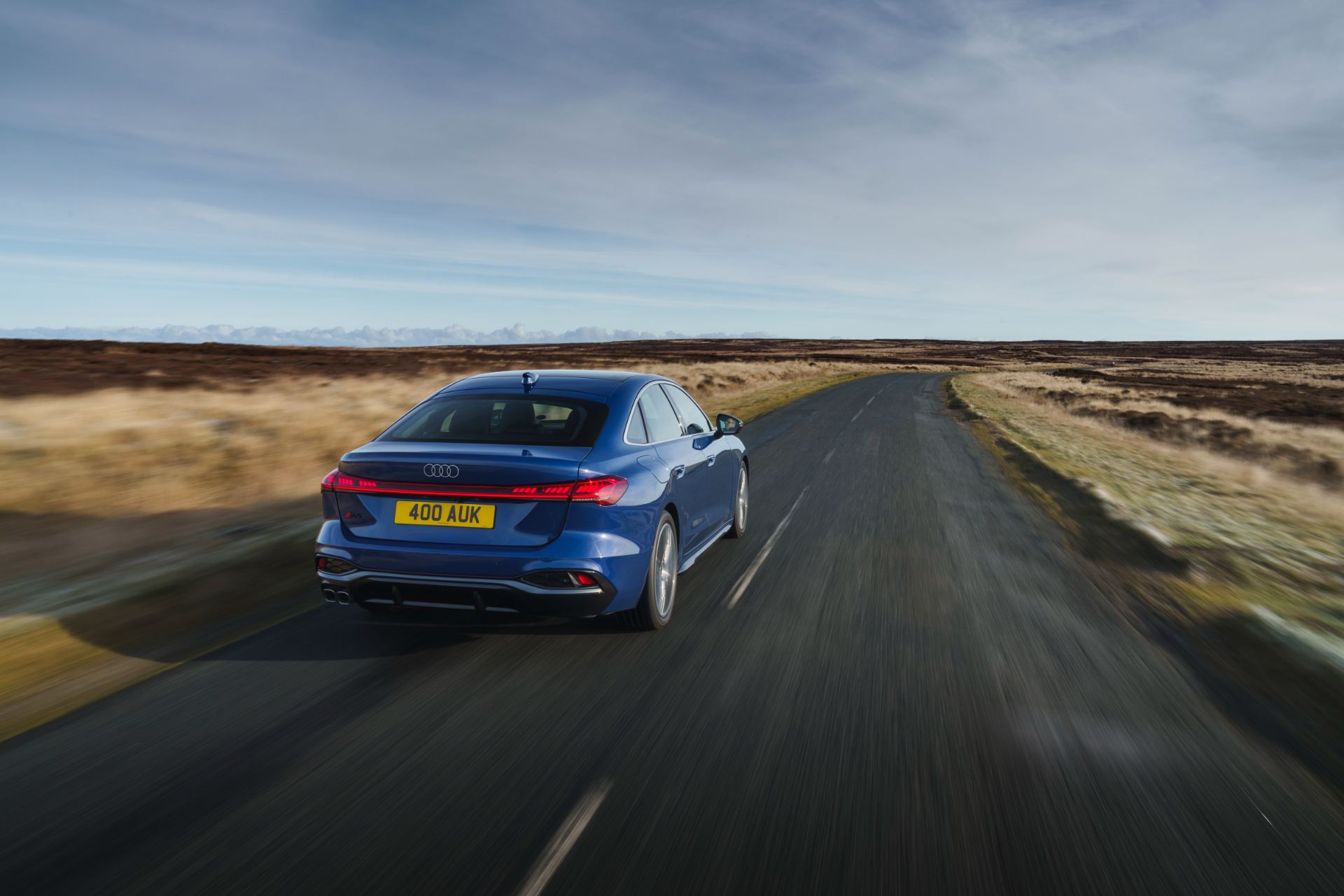 audi a5 saloon driving rear moorland road blue