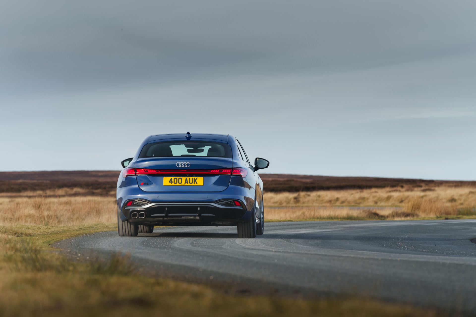 audi a5 saloon driving rear winding road blue