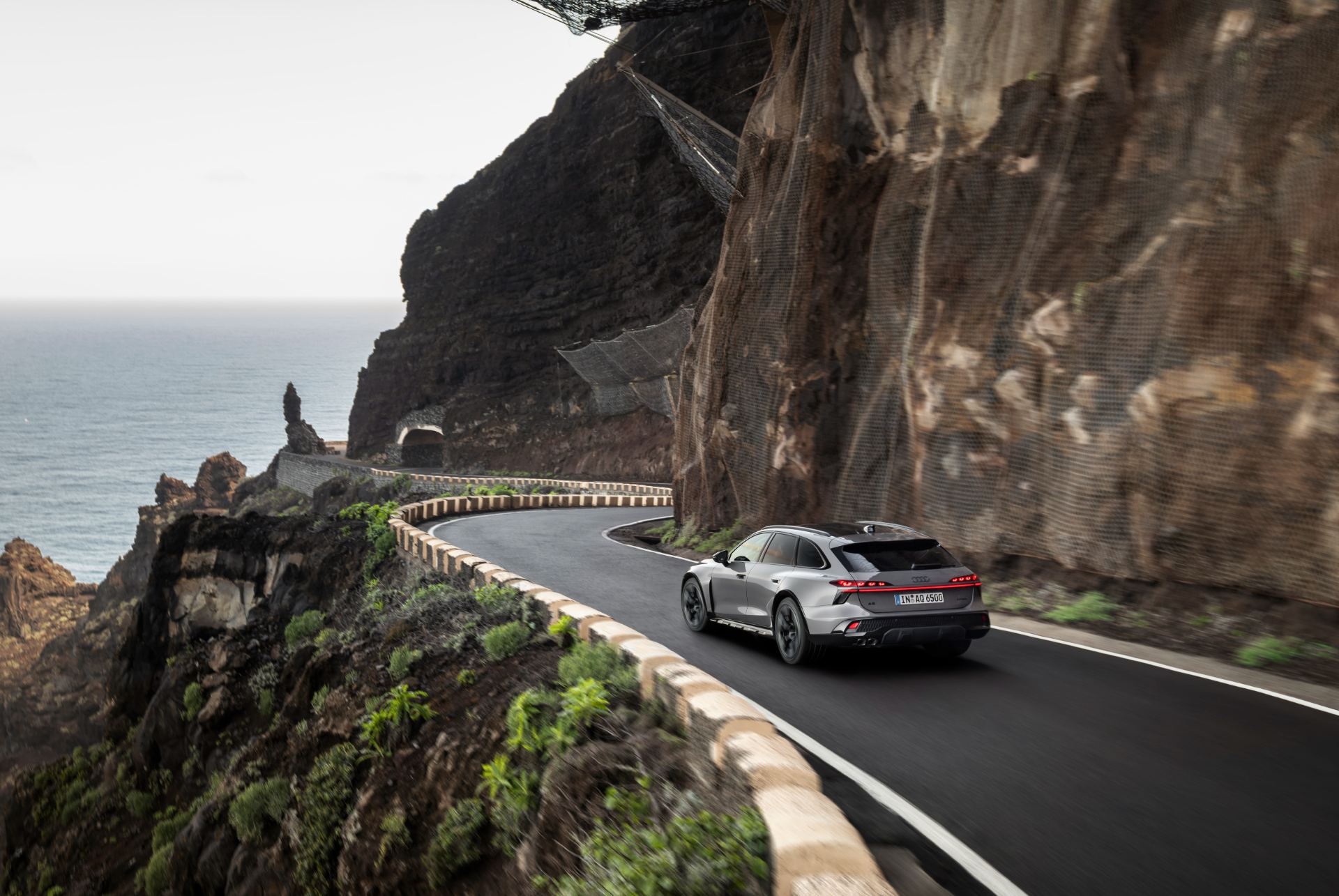 2026 audi a6 allroad driving rear coastal cliff road grey