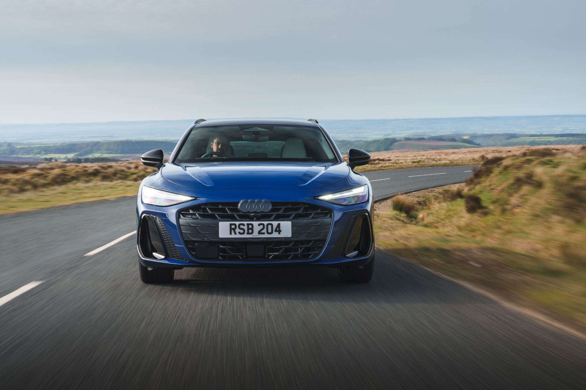 2026 audi a6 avant driving front moorland road blue