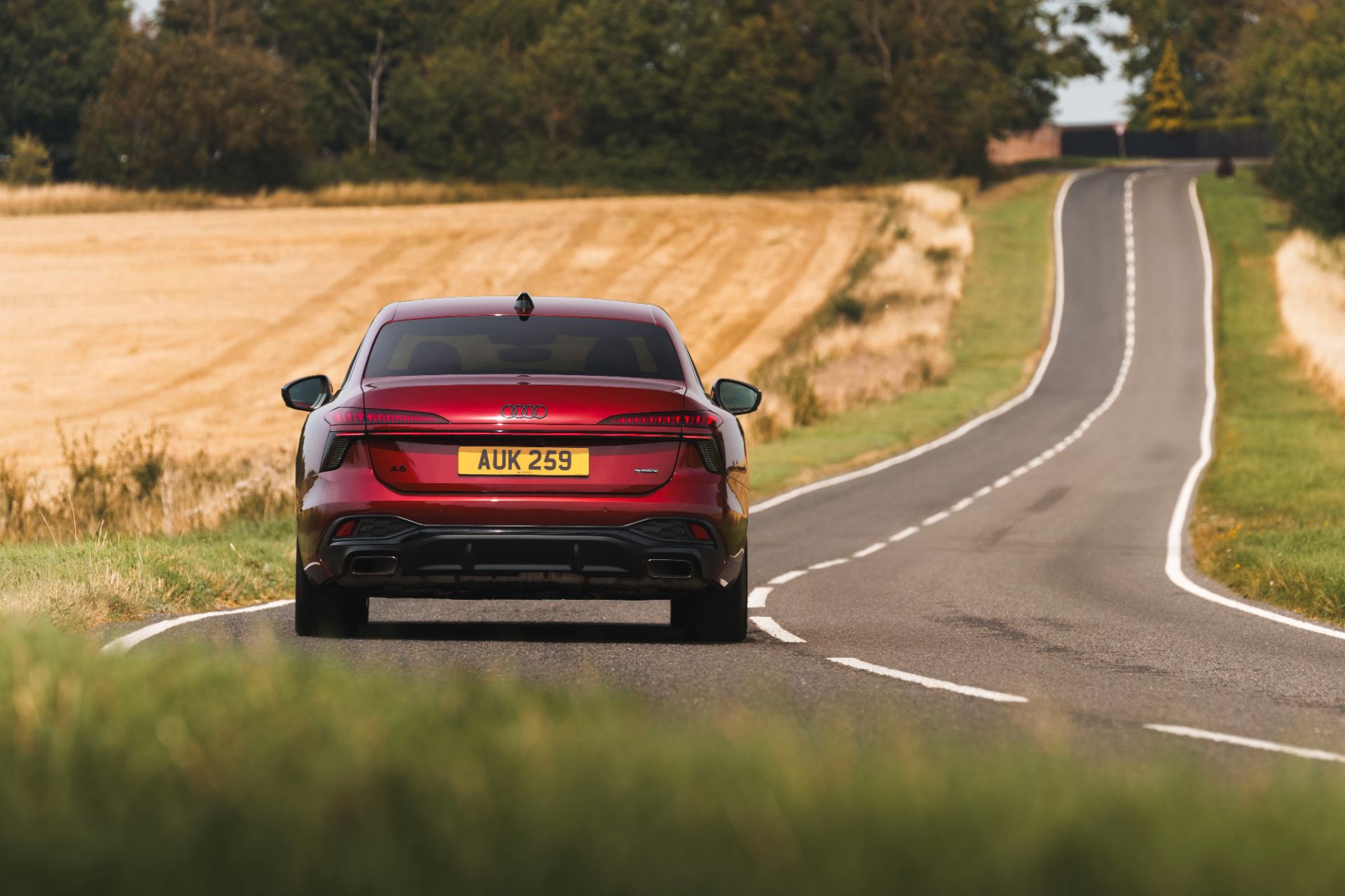 2026 audi a6 saloon e hybrid driving rear country lane red