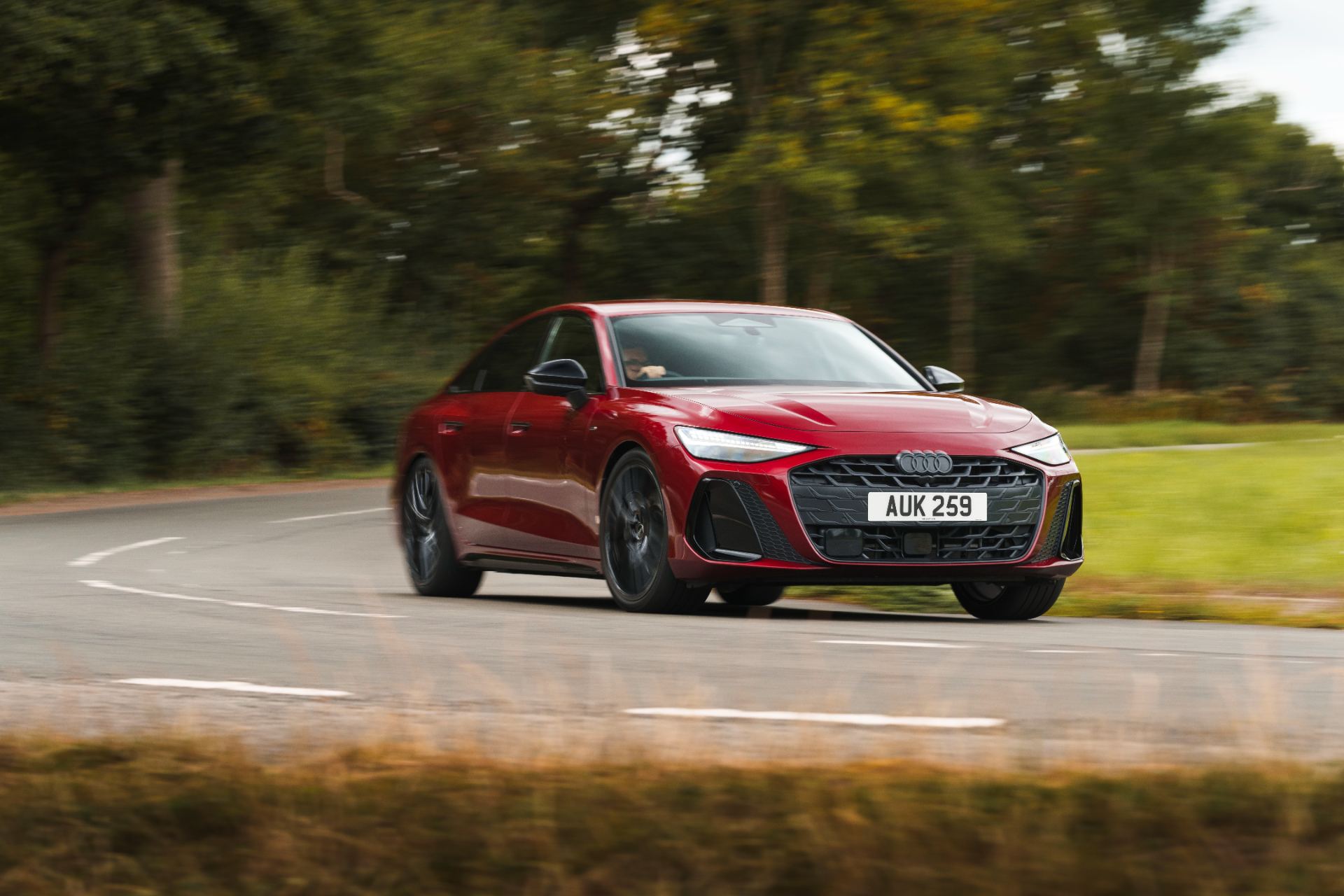 2026 audi a6 saloon e hybrid driving front three quarter bend red