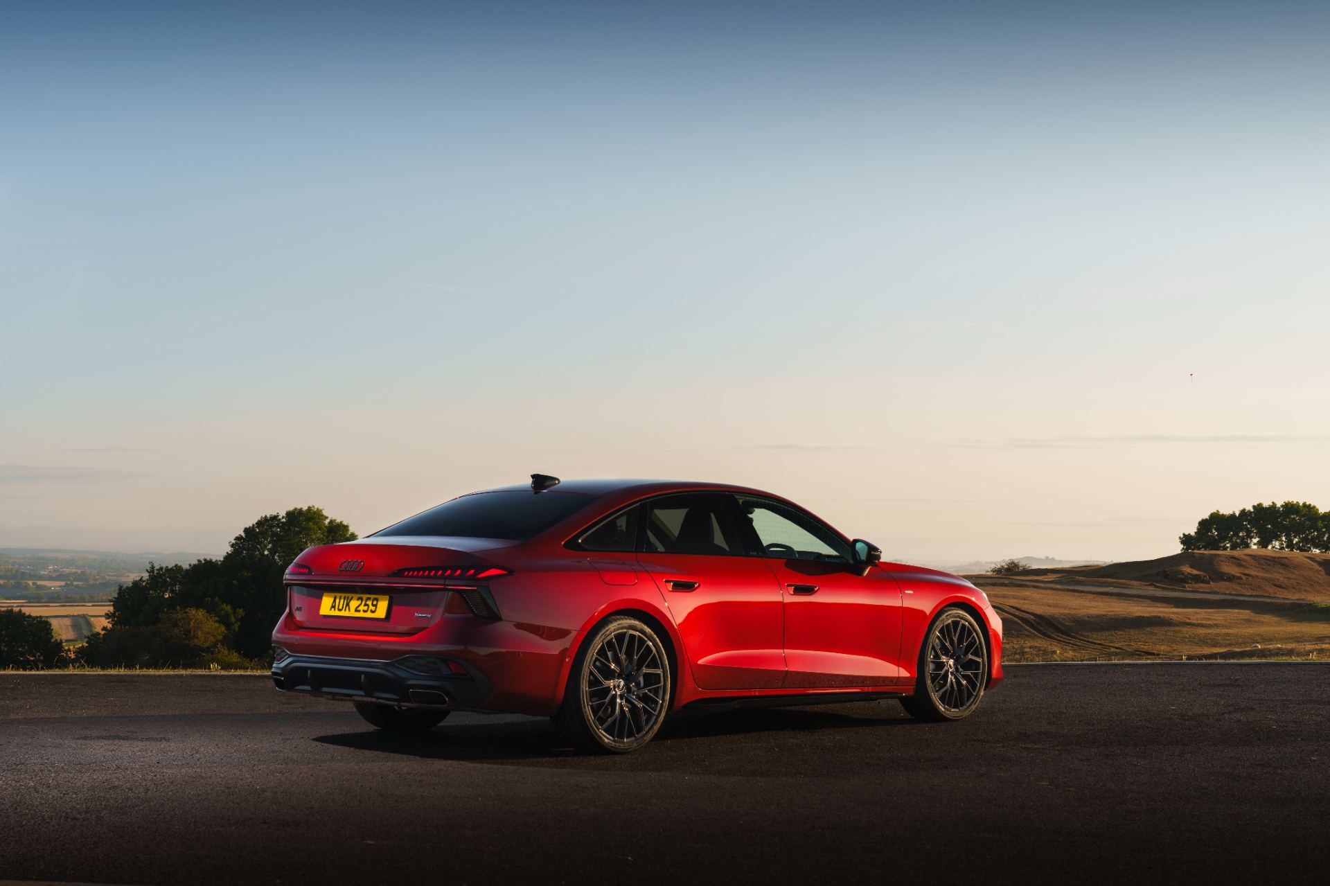 2026 audi a6 saloon e hybrid rear three quarter distant red