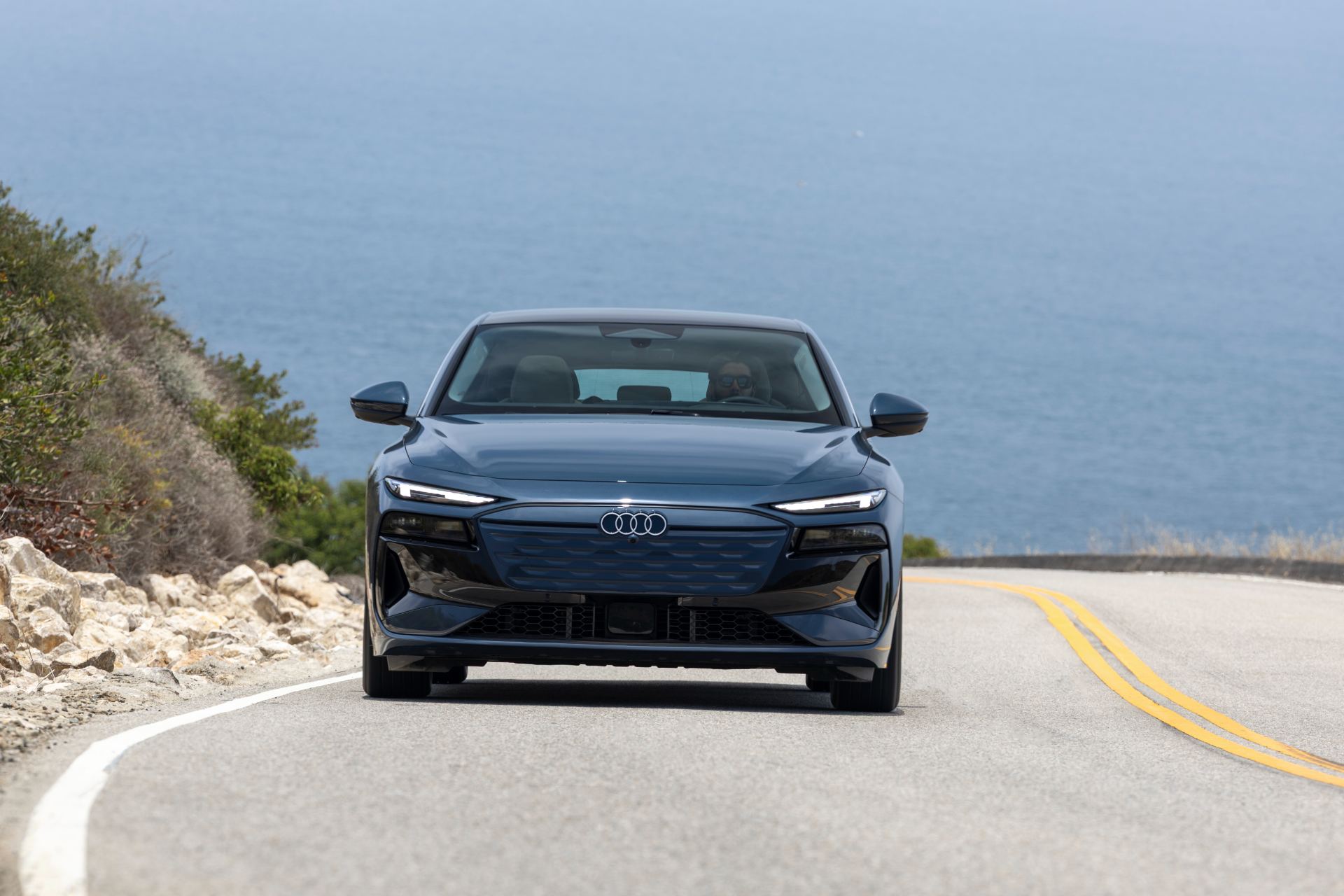 2027 audi a6 sportback e tron driving front coastal road grey