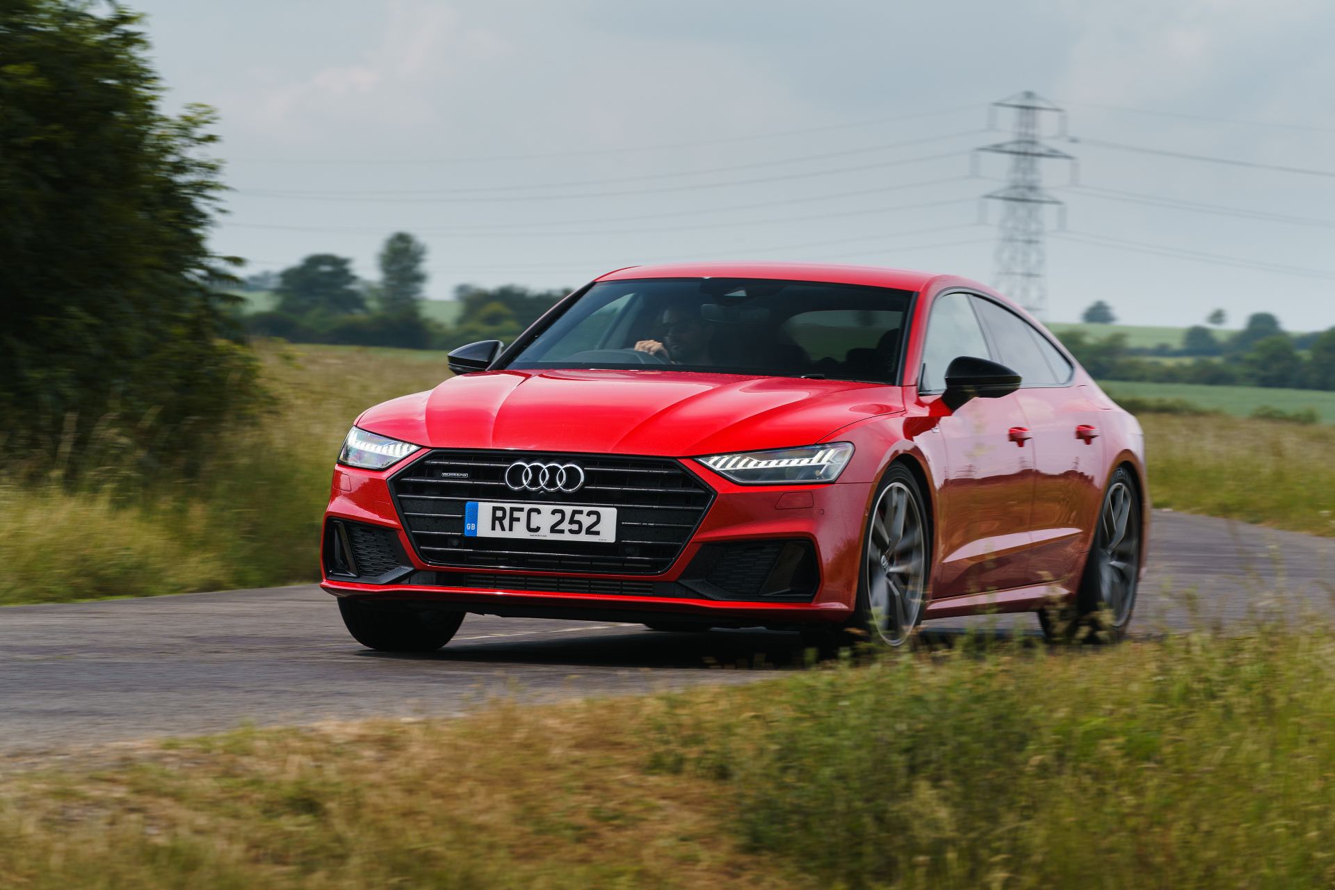 2025 audi a7 sportback front three quarter country lane red