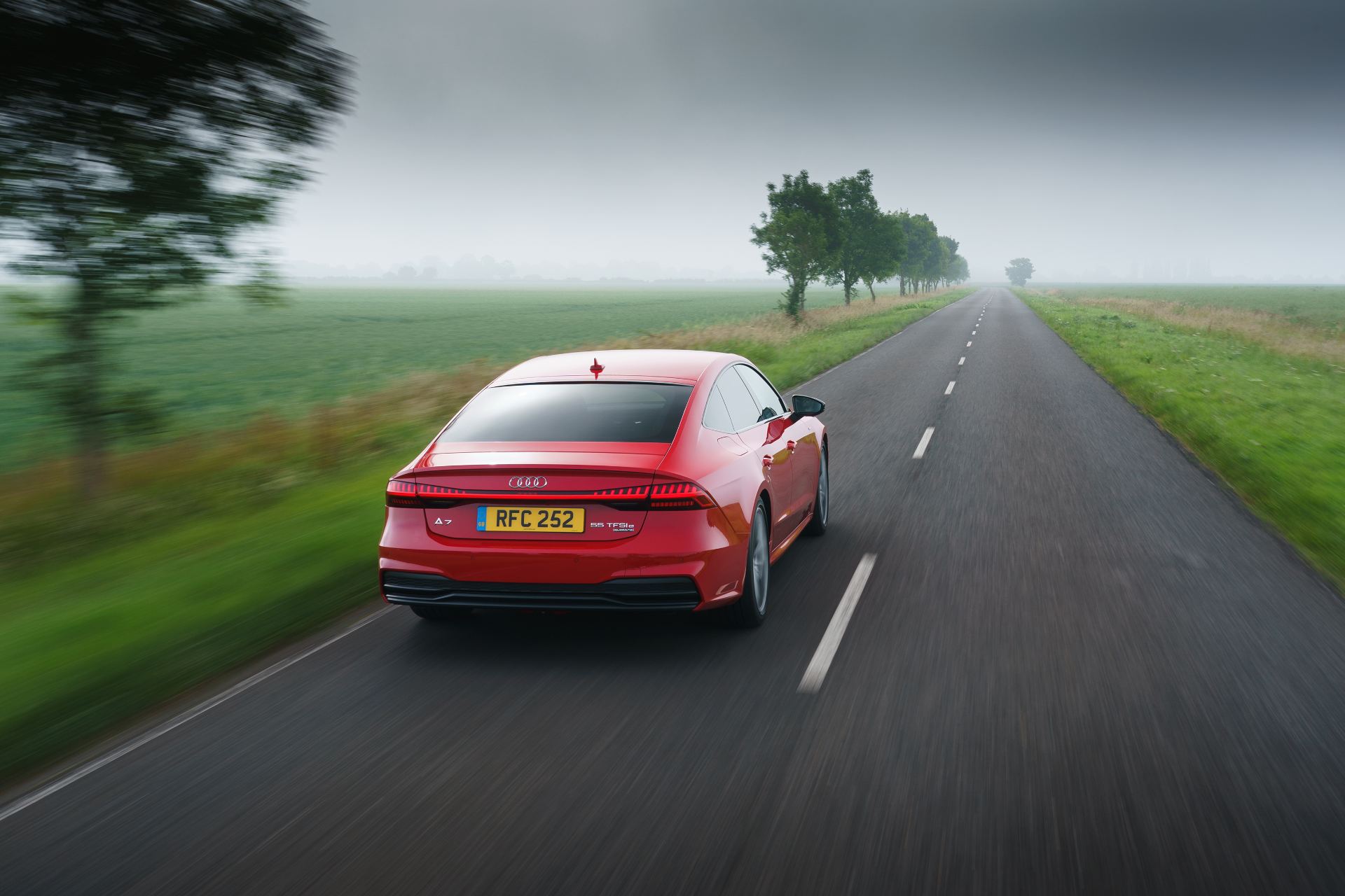 2025 audi a7 sportback driving rear country road red