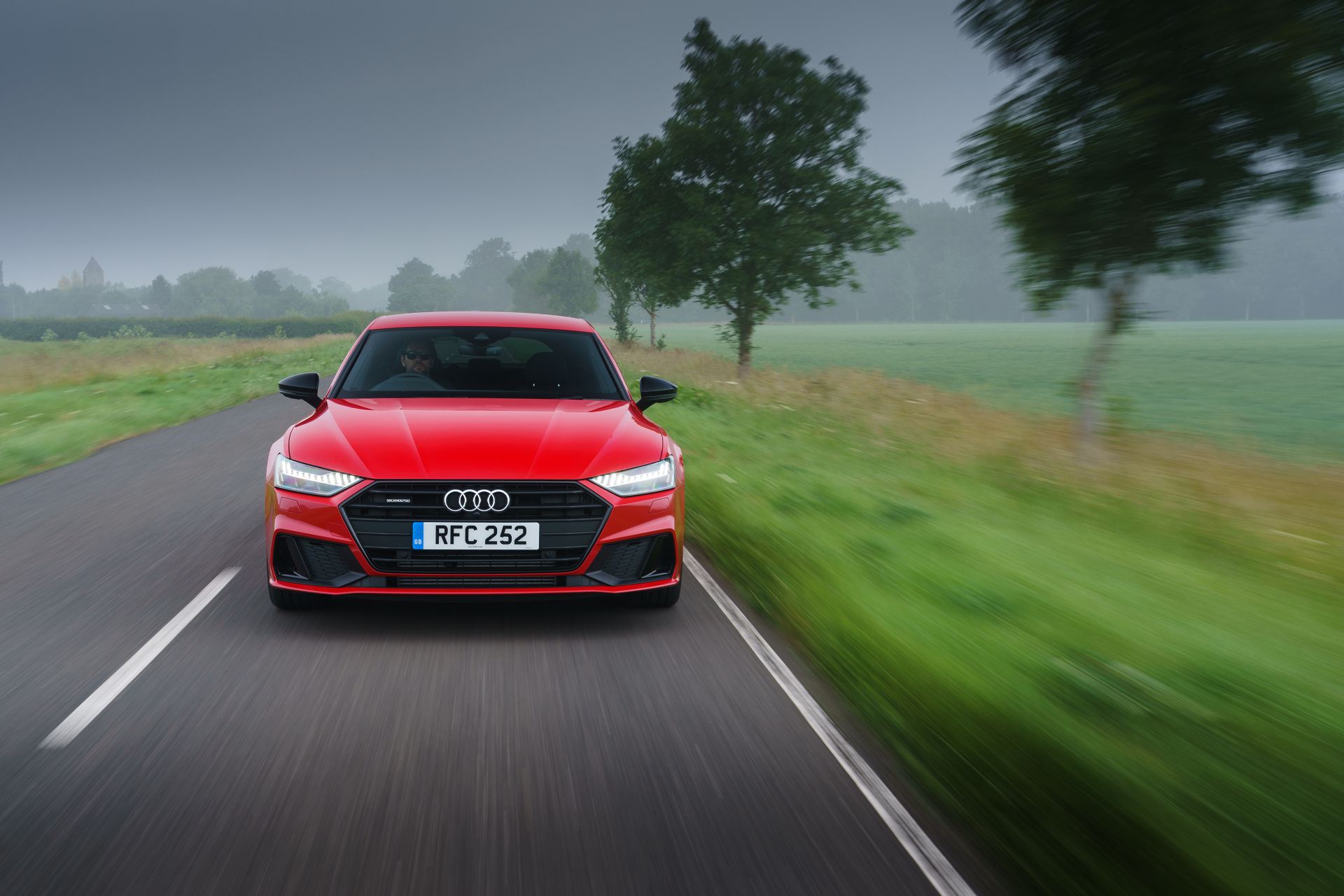 2025 audi a7 sportback driving front country road red