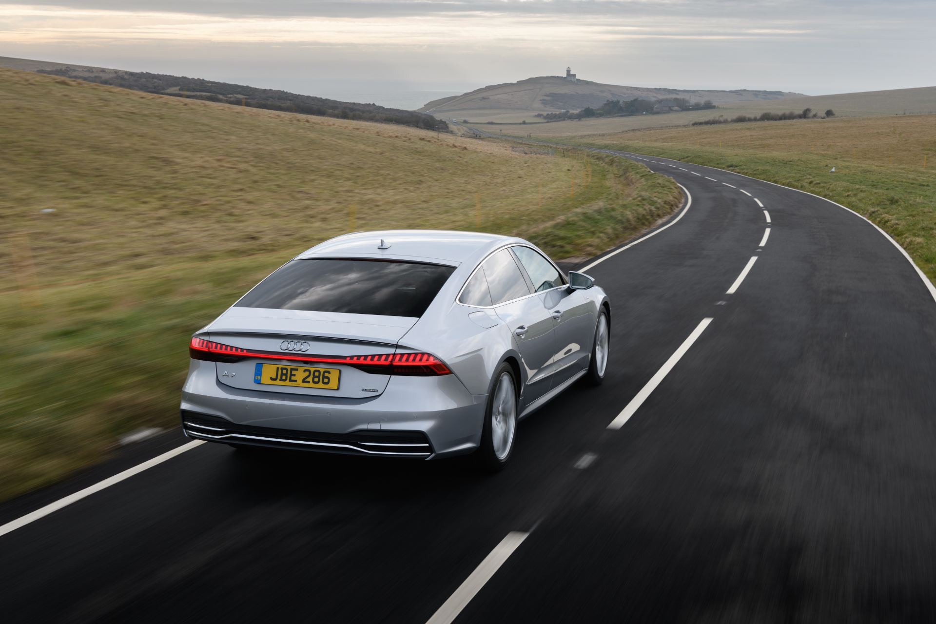 2025 audi a7 sportback driving rear three quarter downs road silver