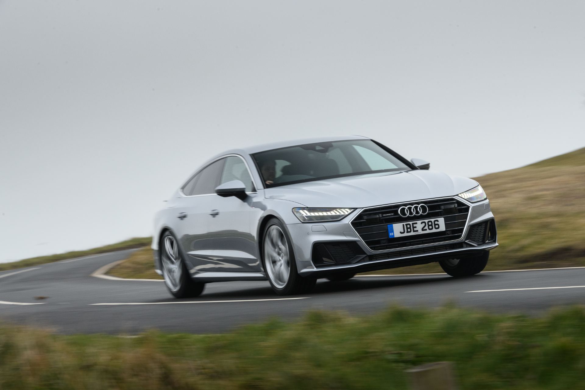 2025 audi a7 sportback driving front three quarter hairpin silver