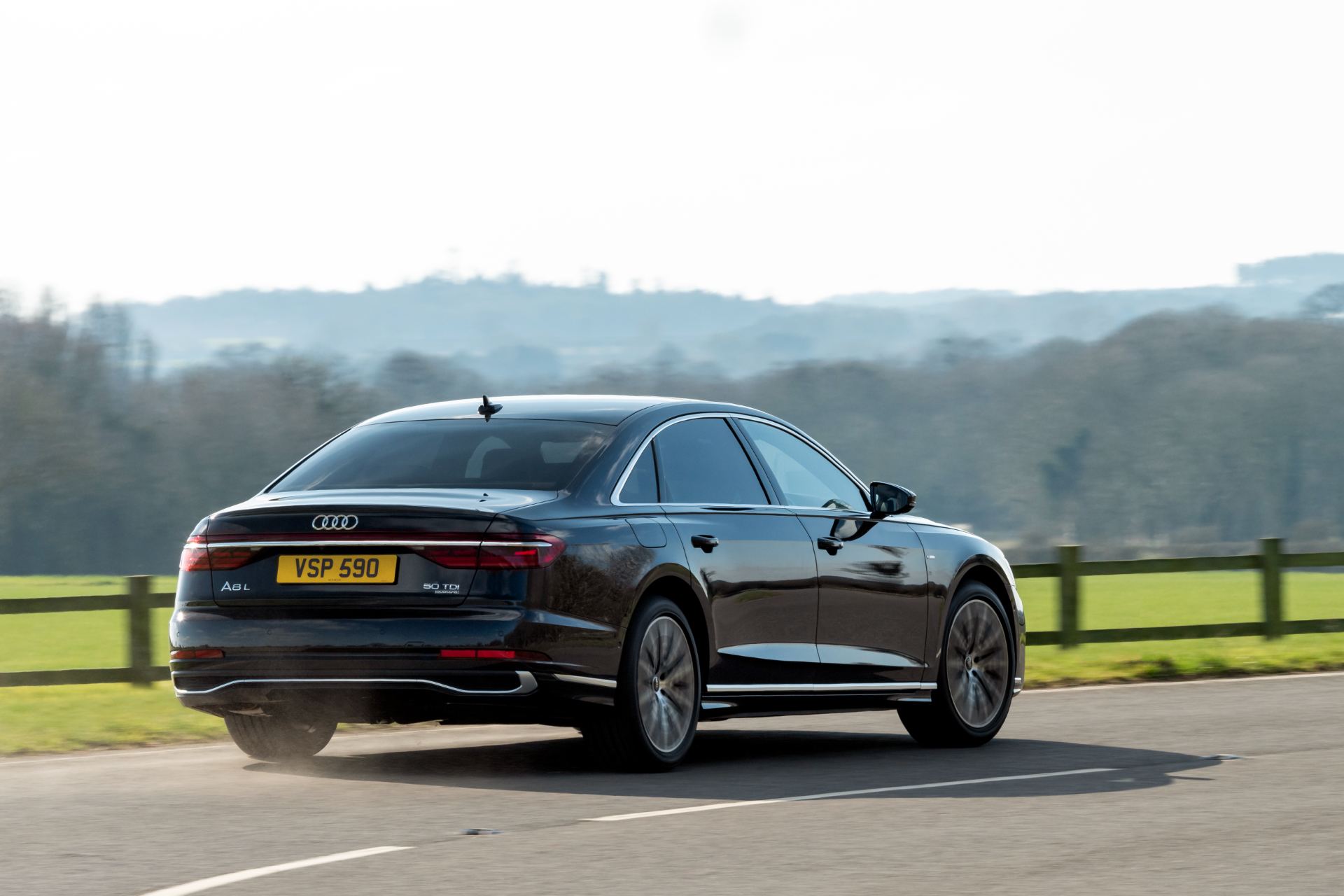 2025 audi a8 driving rear three quarter black