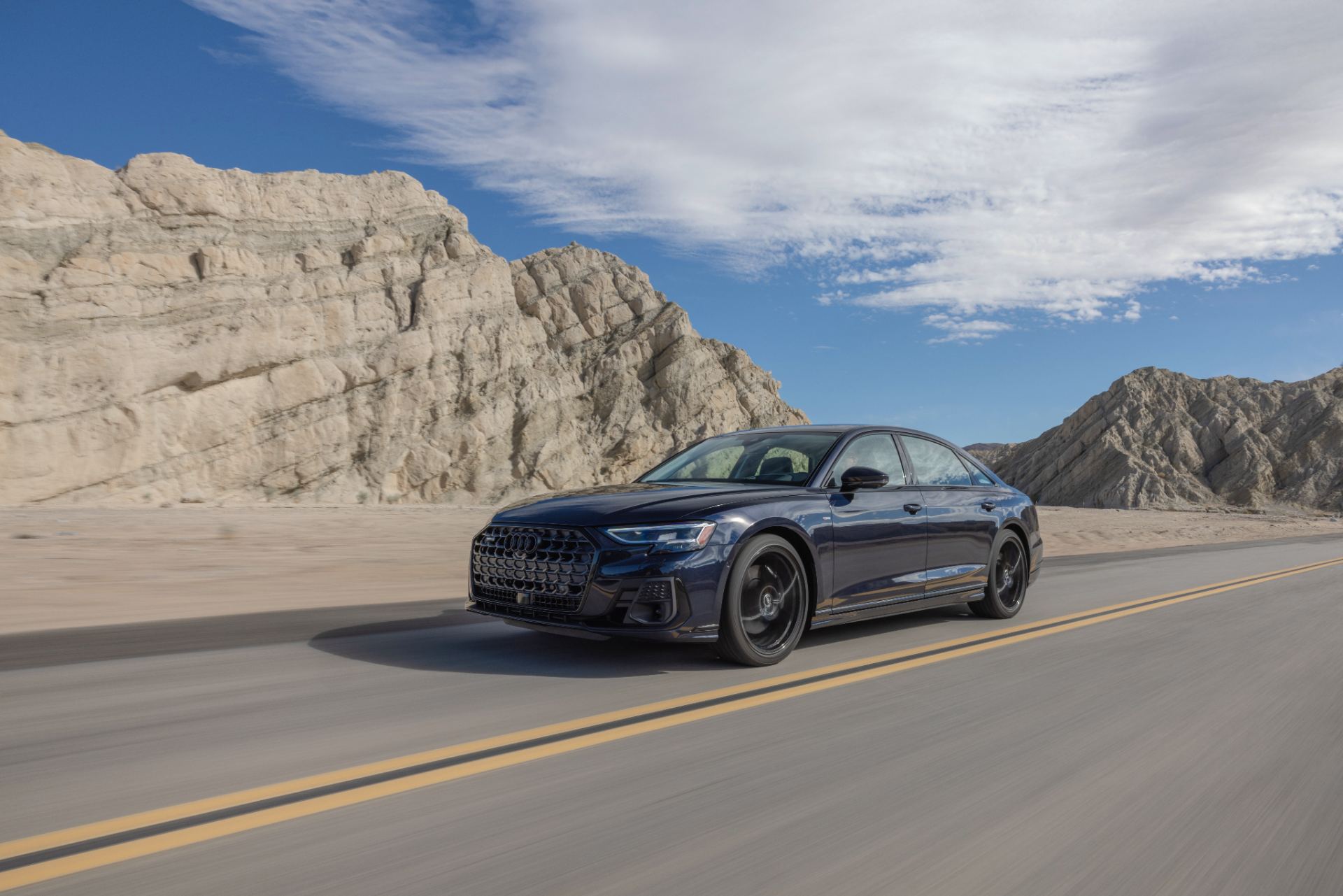 audi a8 l driving front three quarter desert road dark blue