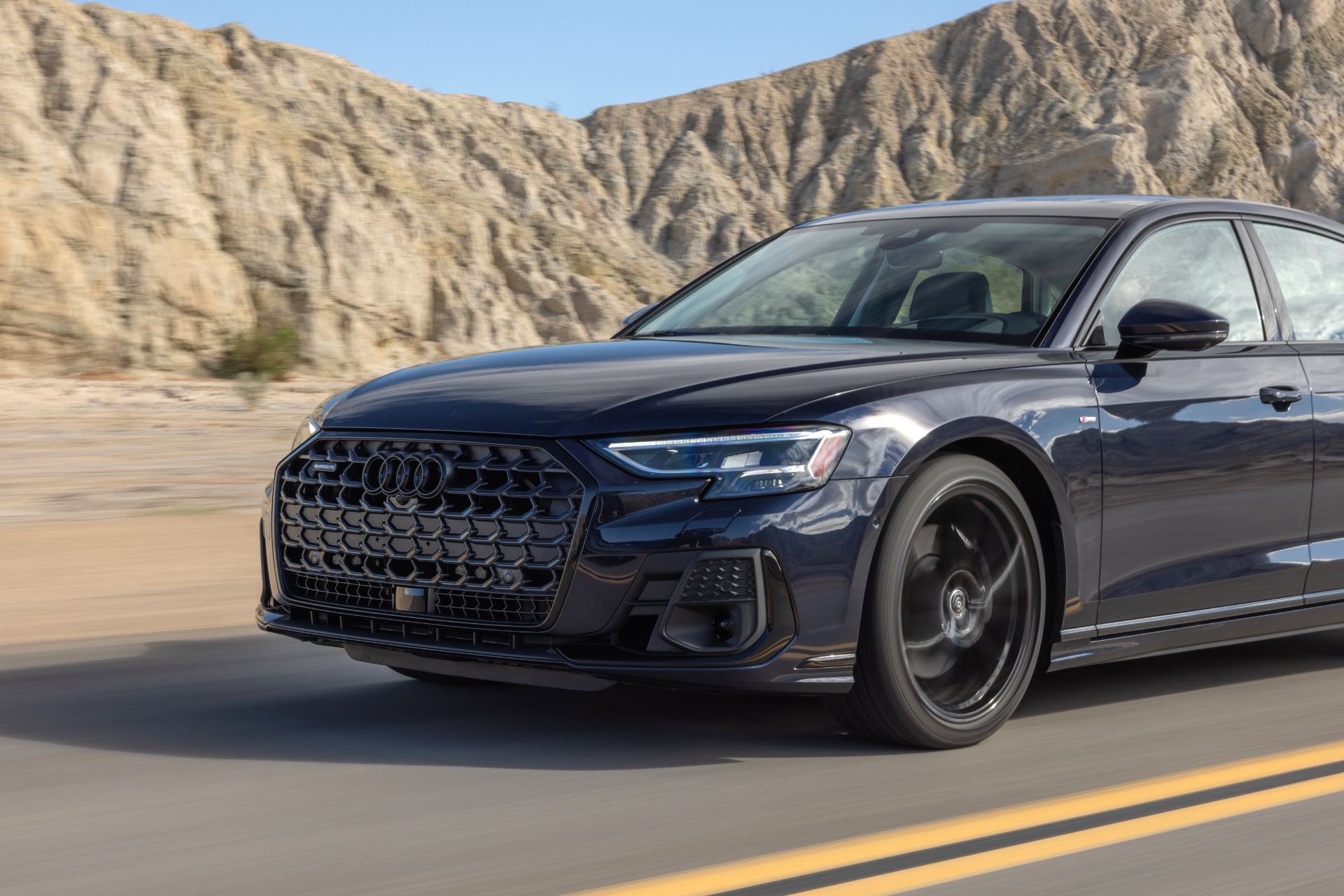 audi a8 l driving front three quarter desert dark blue