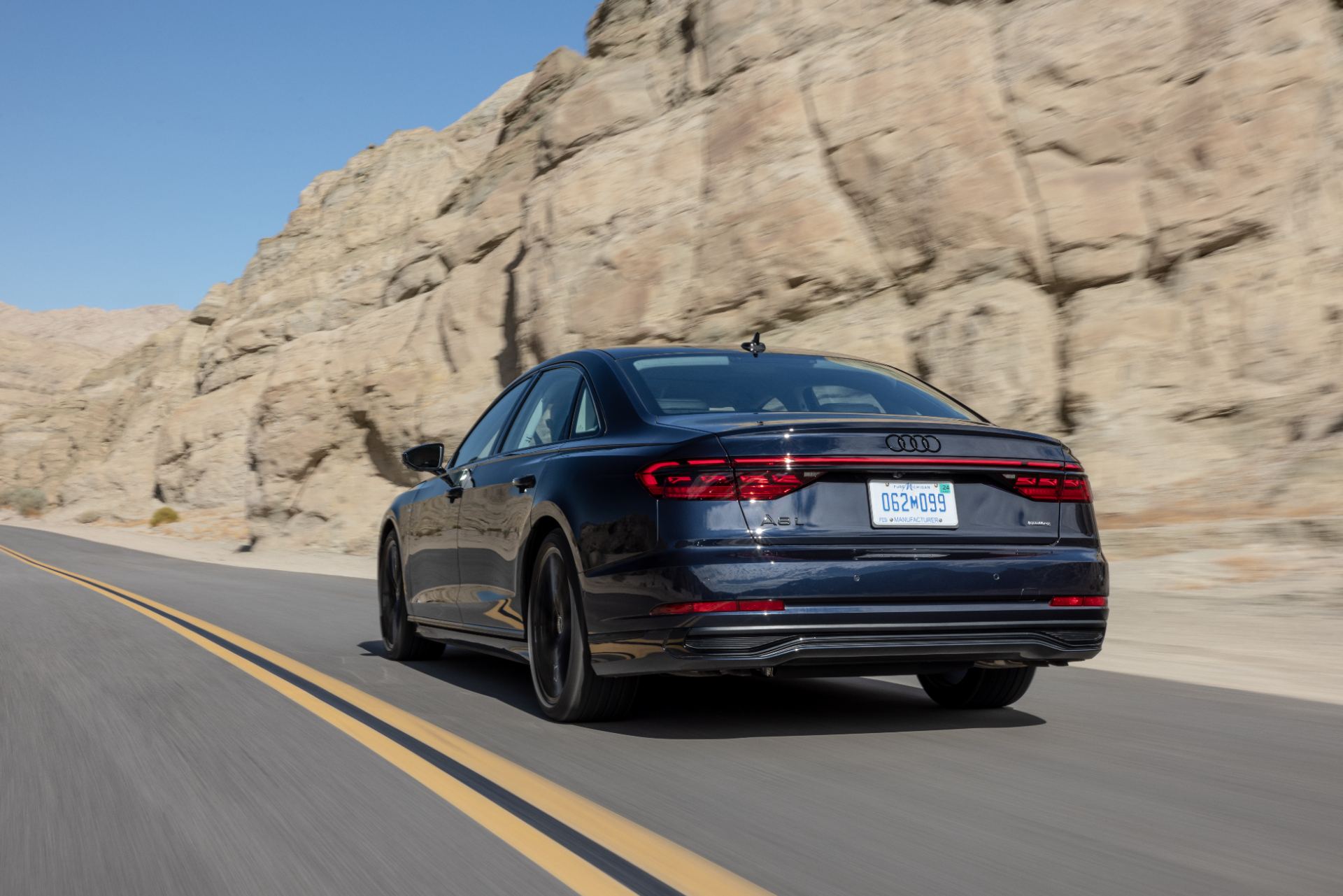 audi a8 l driving rear desert road dark blue