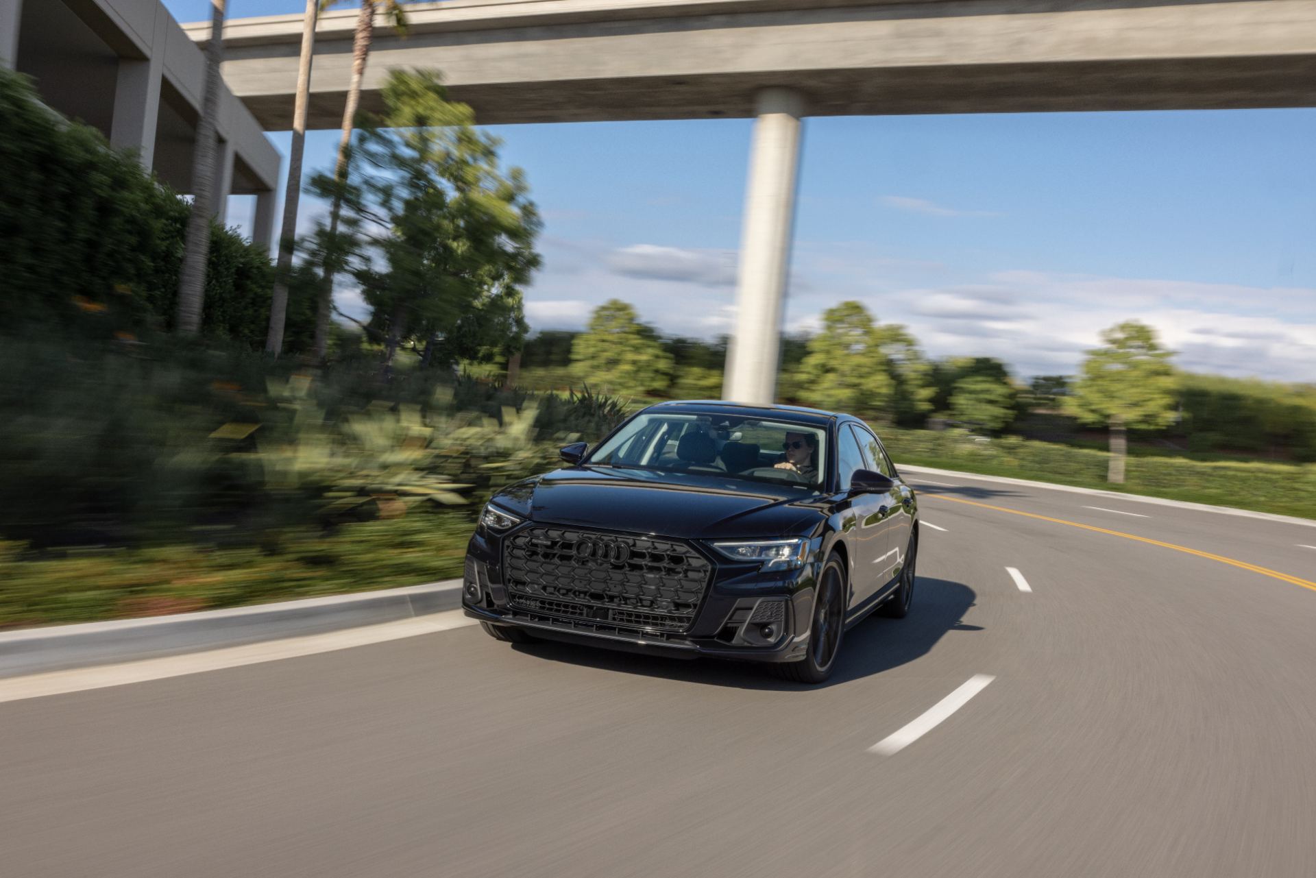audi a8 l driving front three quarter overpass dark blue