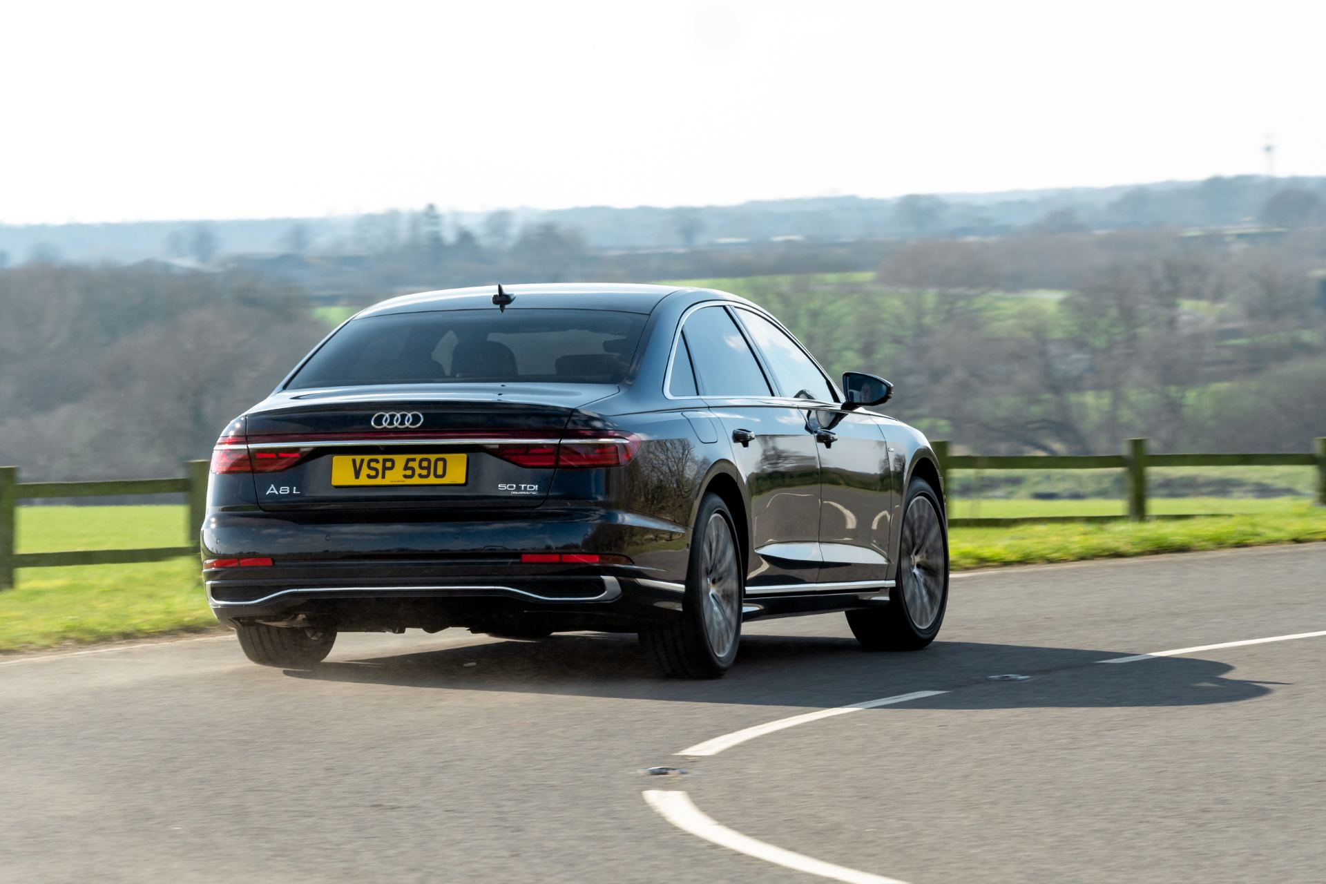 2025 audi a8 l driving rear three quarter black