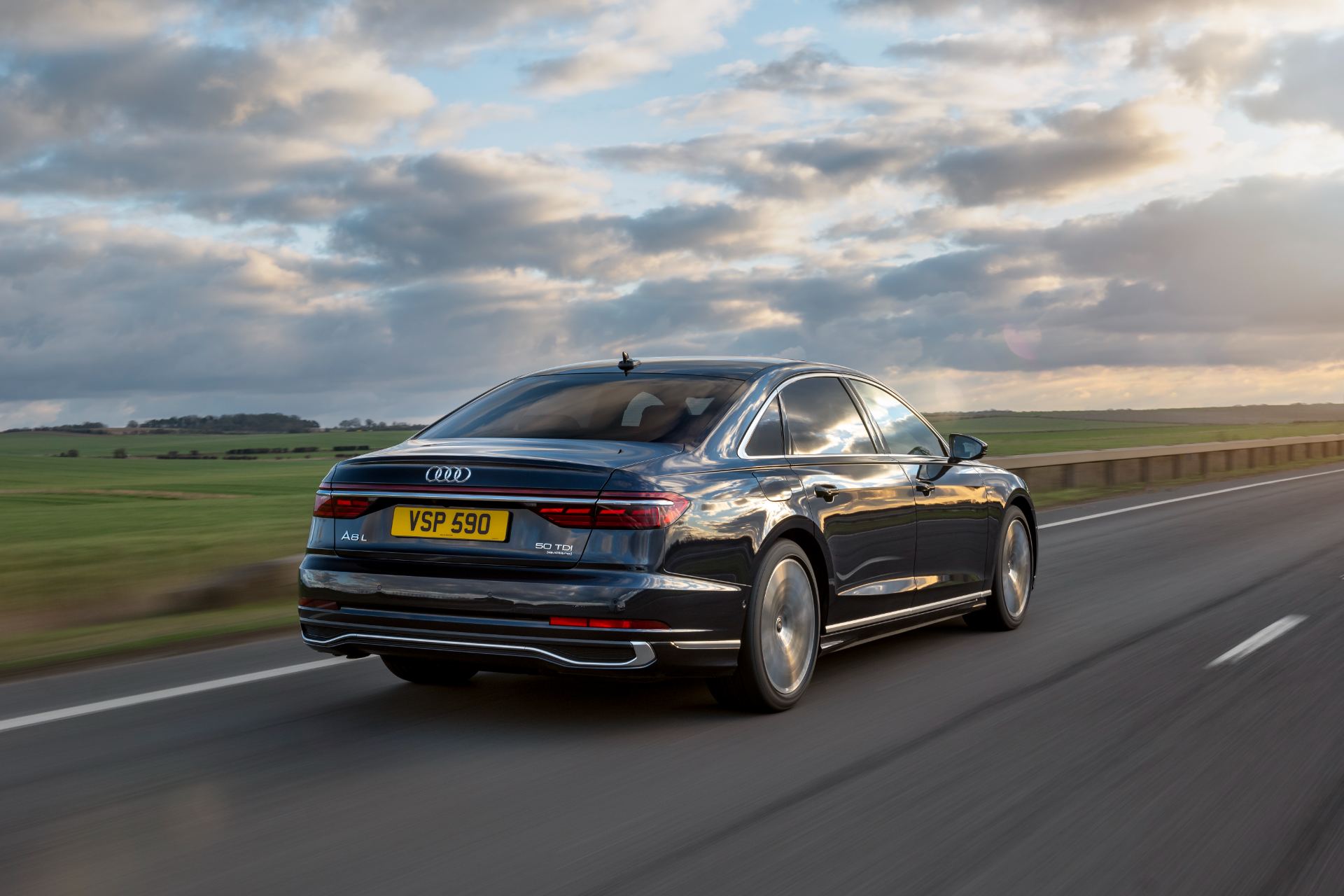 2025 audi a8 l driving rear three quarter moorland black