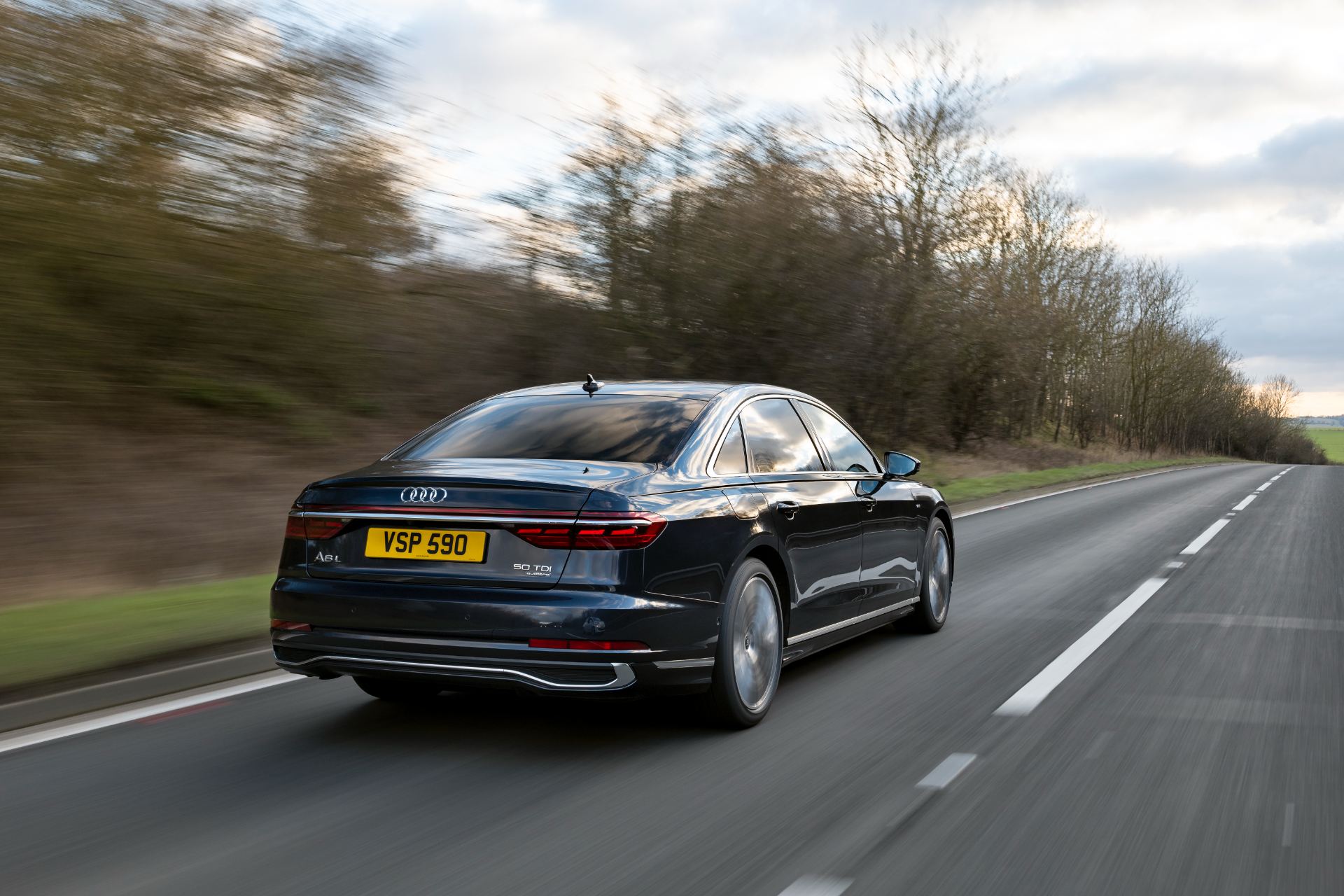 2025 audi a8 l driving rear three quarter trees black