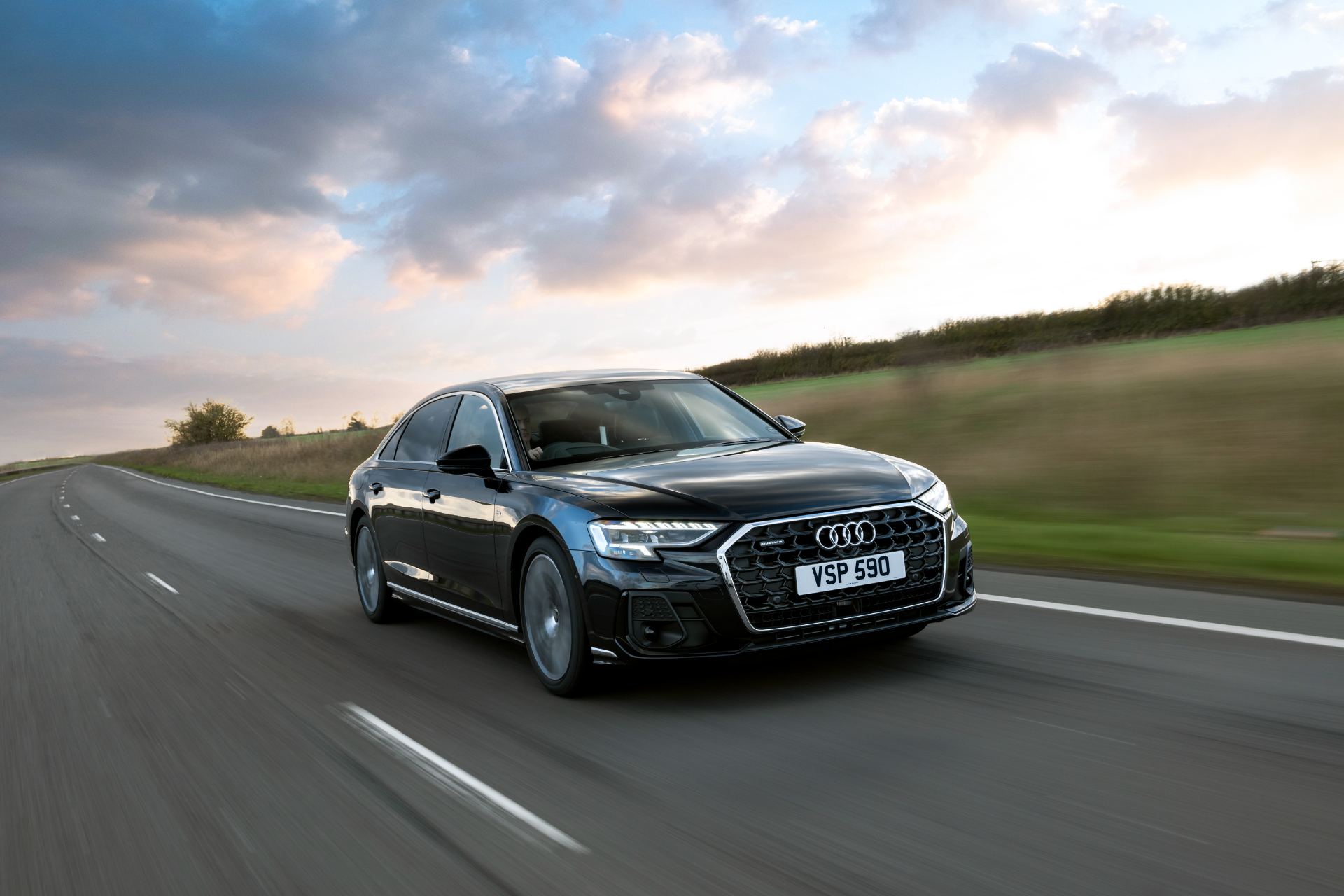 2025 audi a8 l driving front three quarter clouds black