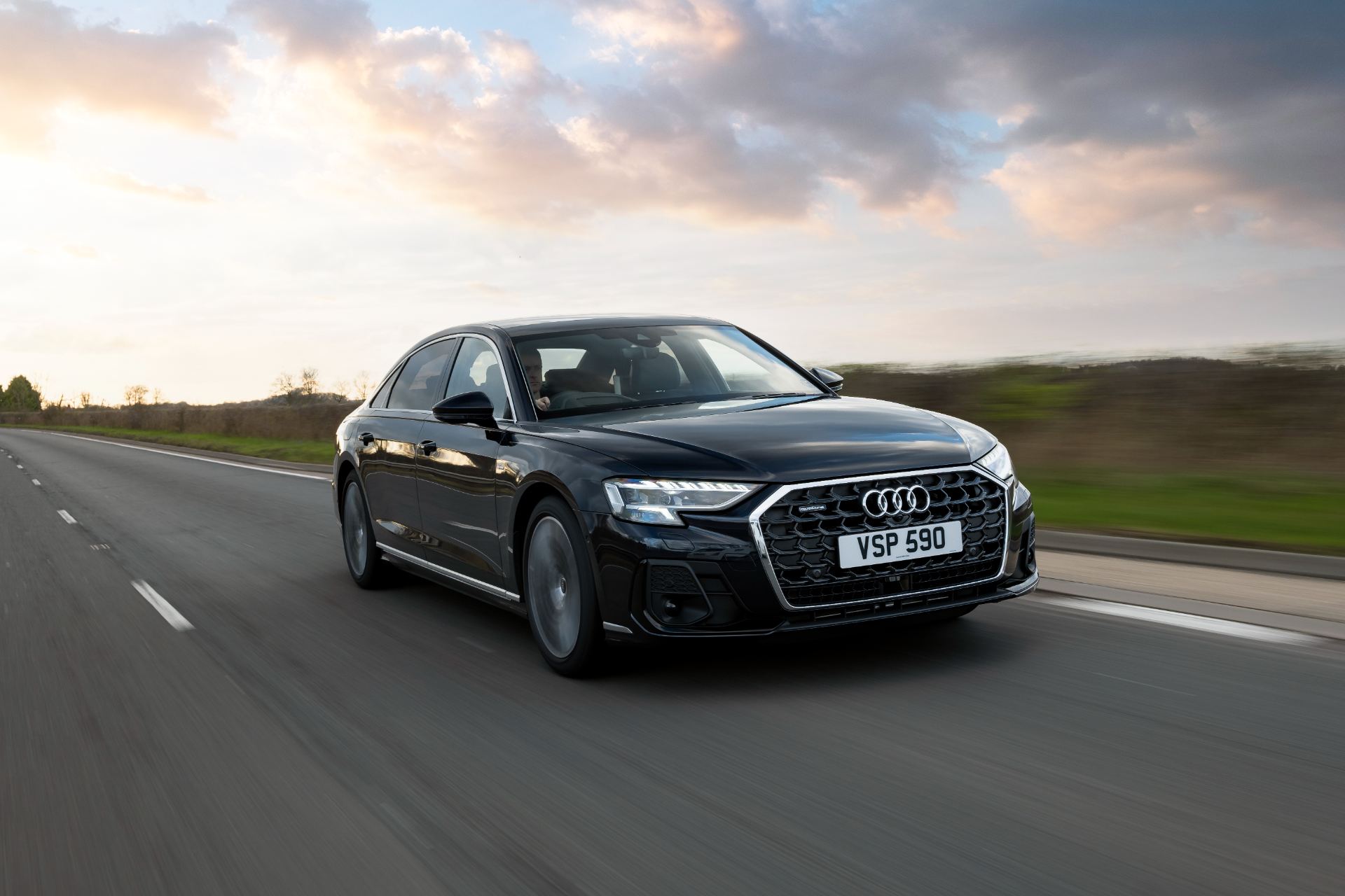 2025 audi a8 l driving front three quarter sunset black