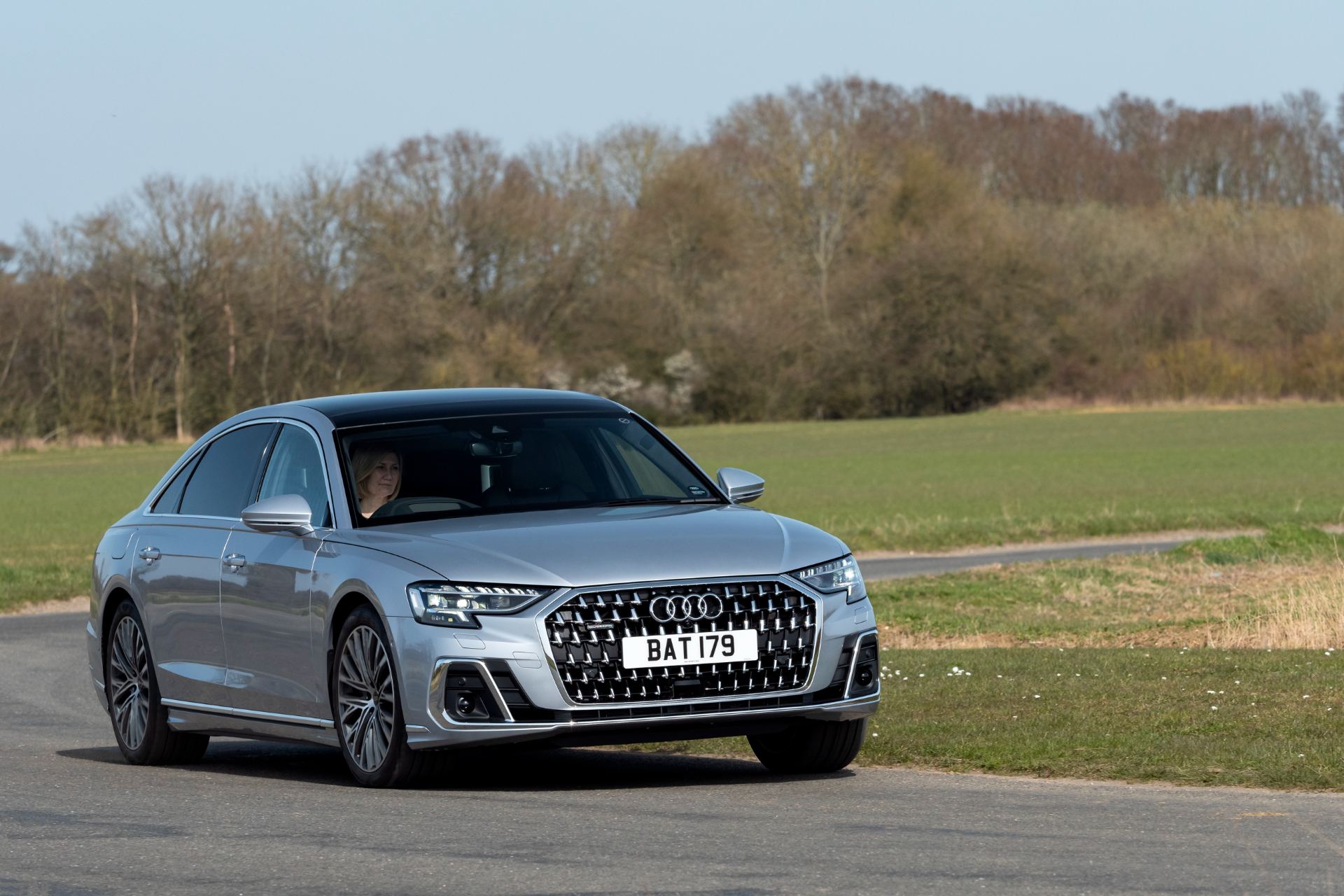 2025 audi a8 60 tfsi e driving front three quarter silver