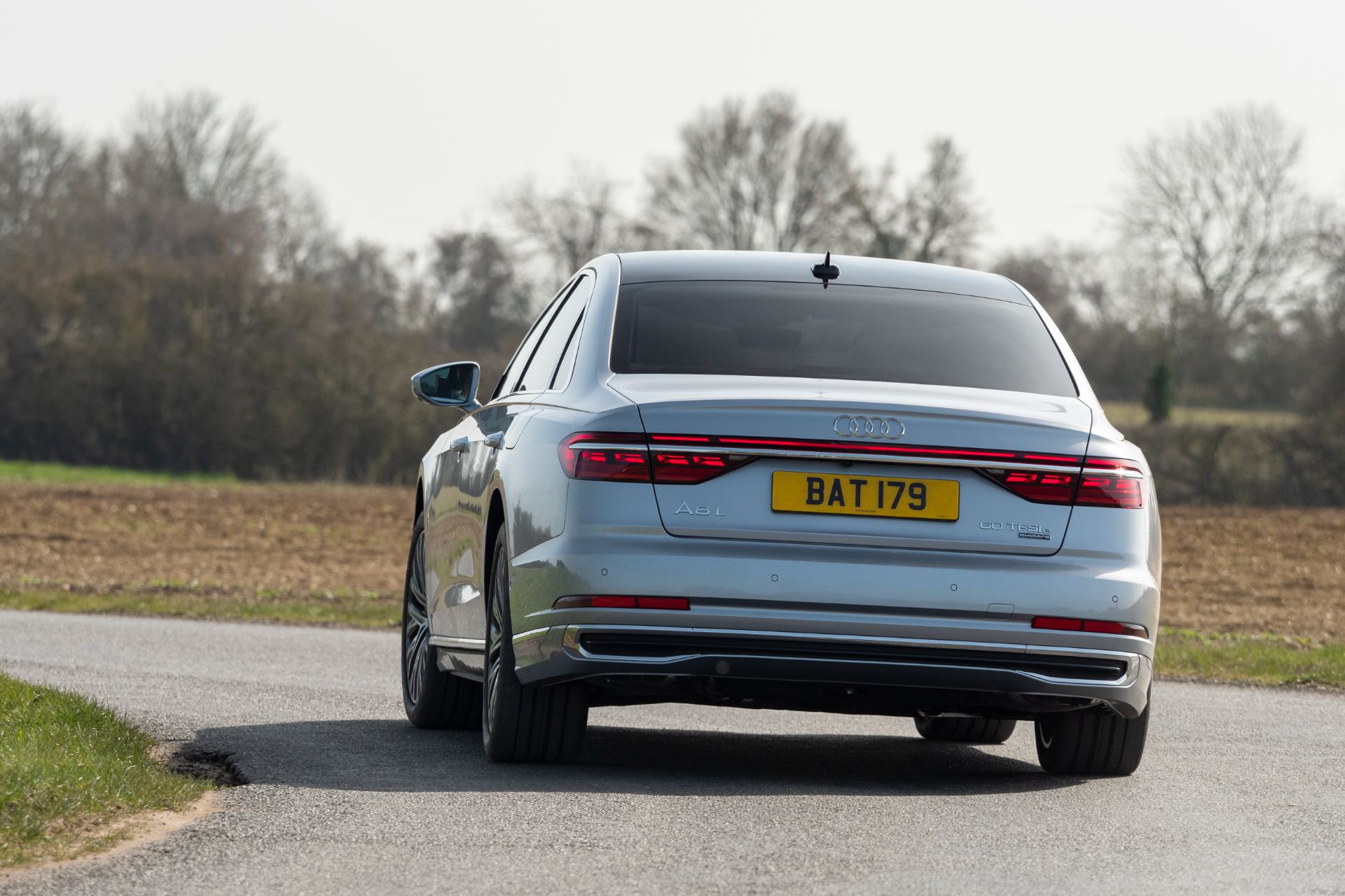 2025 audi a8 60 tfsi e driving rear silver