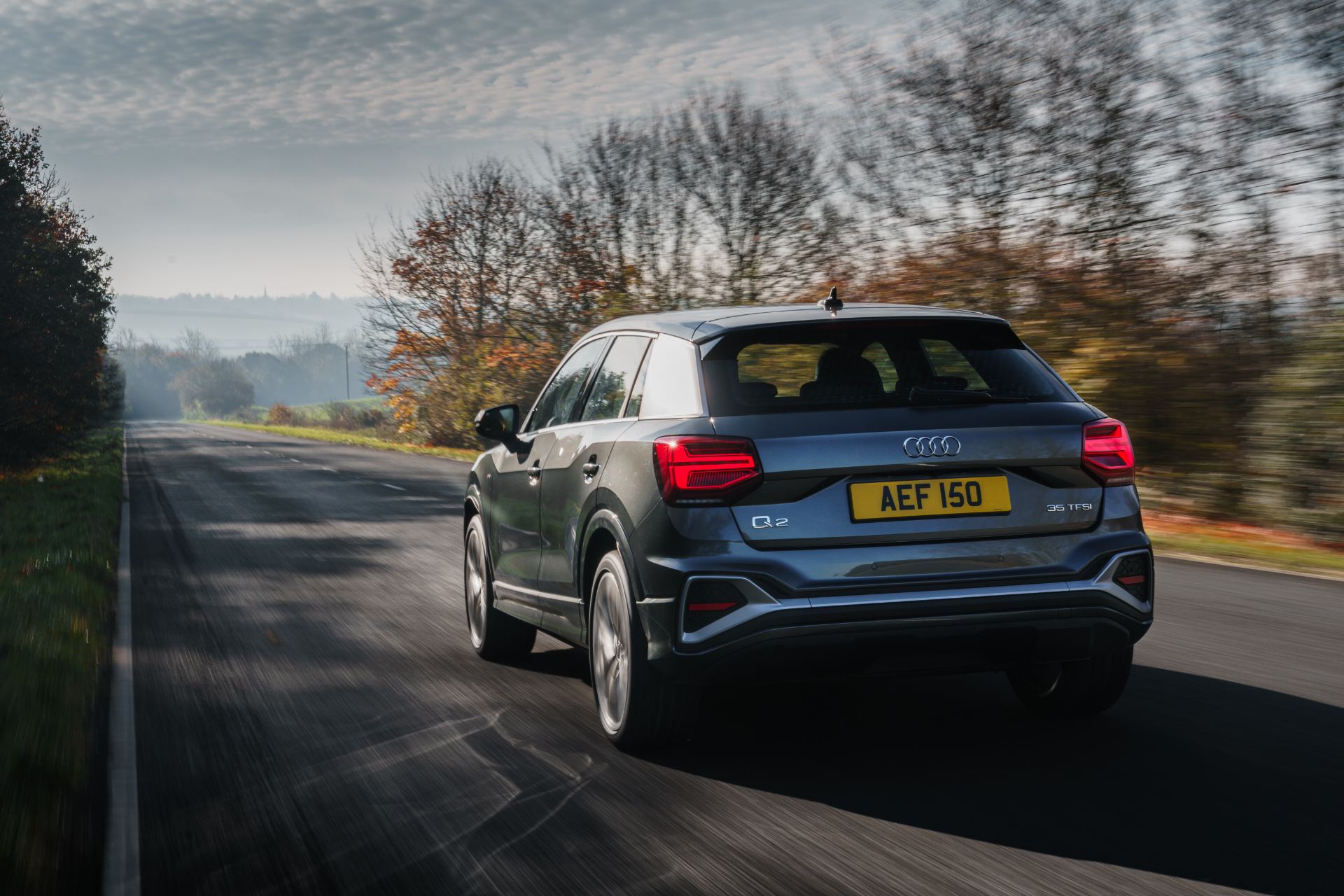 2025 audi q2 driving rear three quarter autumn road grey